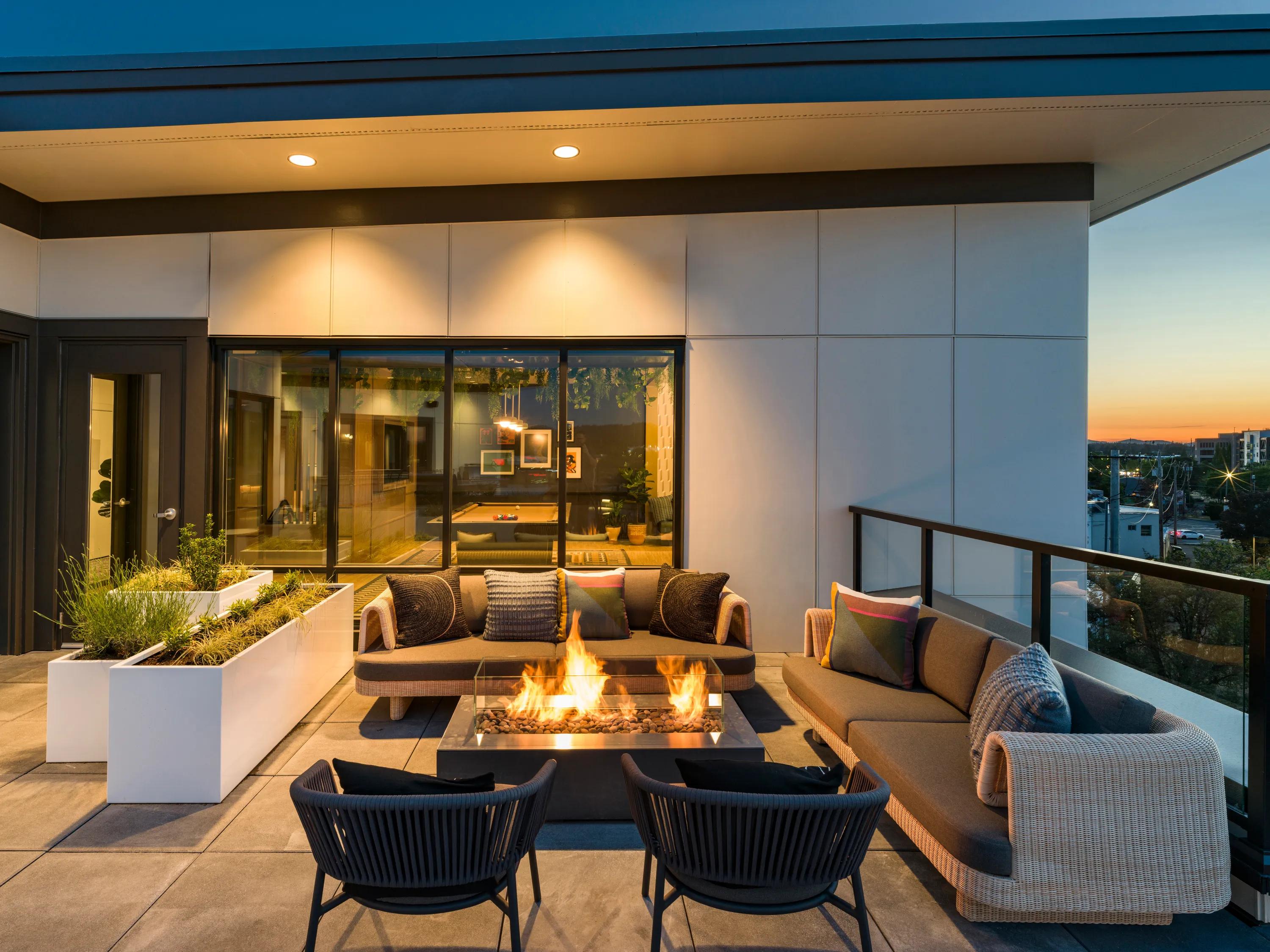 Rooftop deck and bar lounge with covered outdoor terrace, fire table, lounge seating, and sweeping neighborhood views