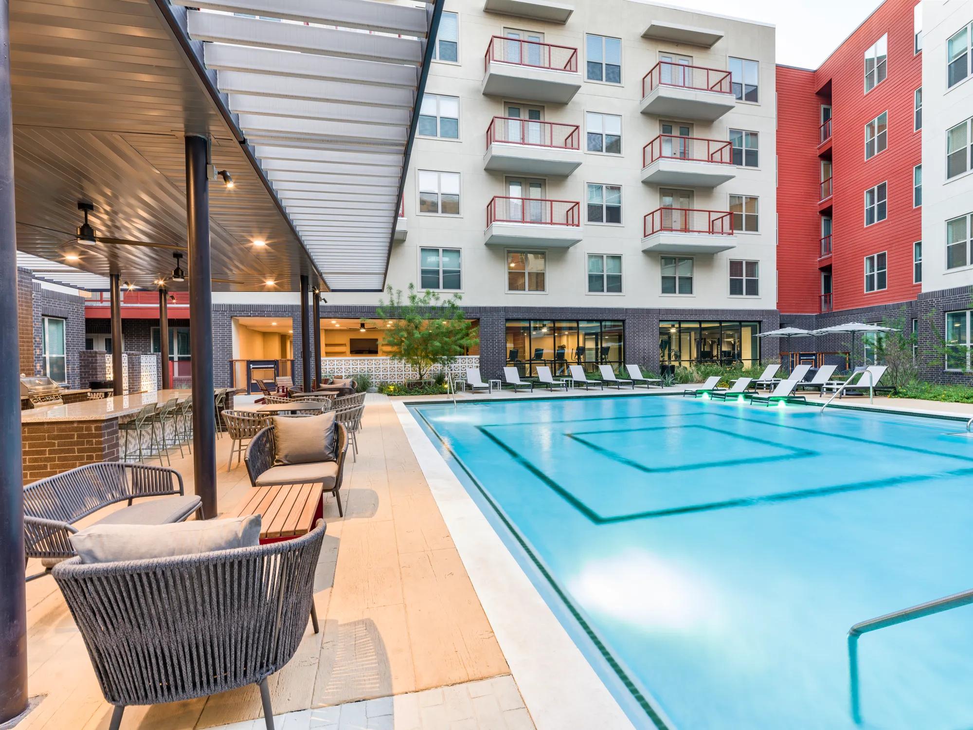 couple swimming in pool and smiling modera eado apartment homes for rent in austin texas
