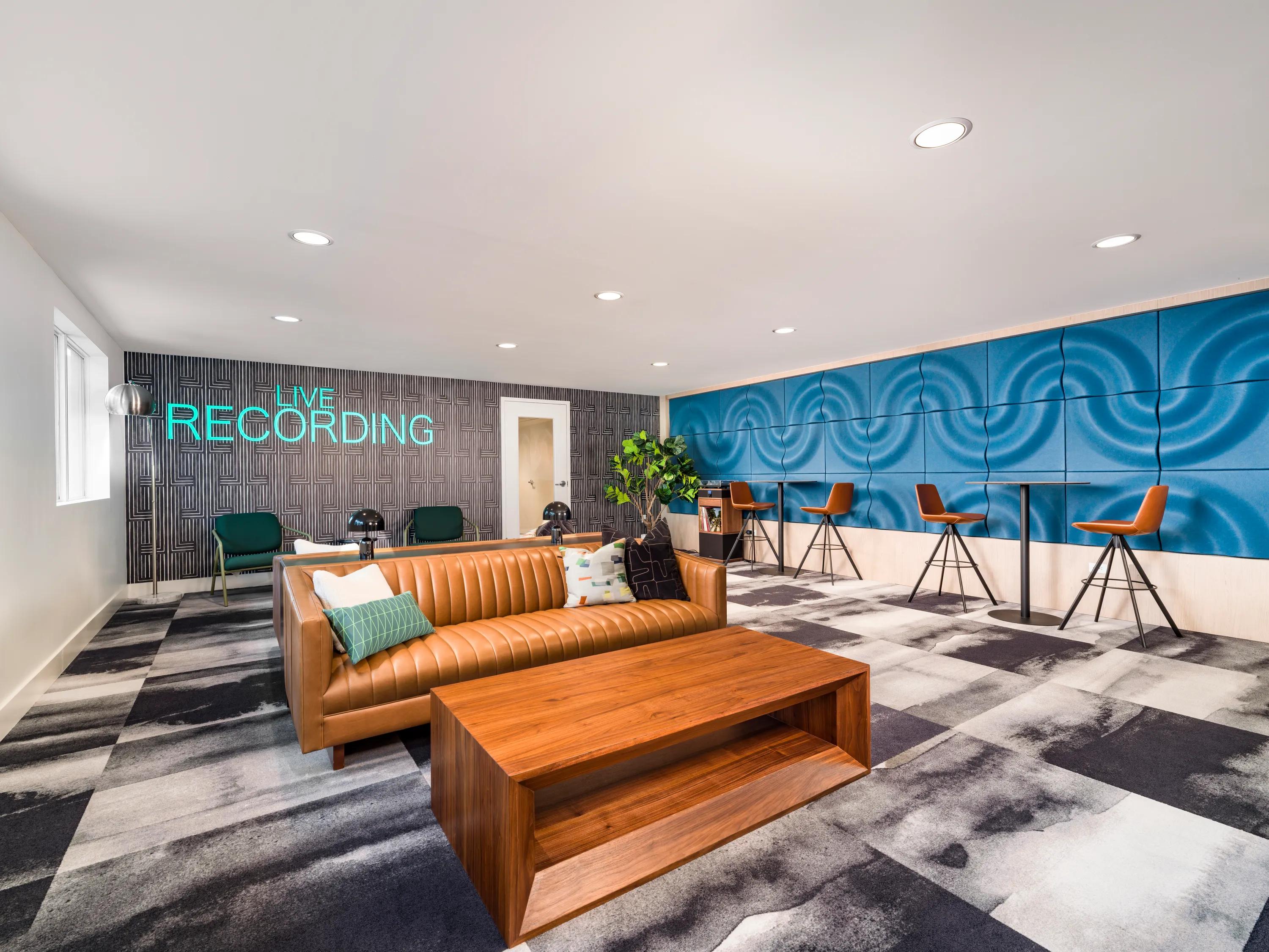 Resident coworking lounge with collaborative seating, individual workstations, contemporary furnishings, and dedicated spaces for remote work and productivity at Modera Encore apartments in Tampa, FL.