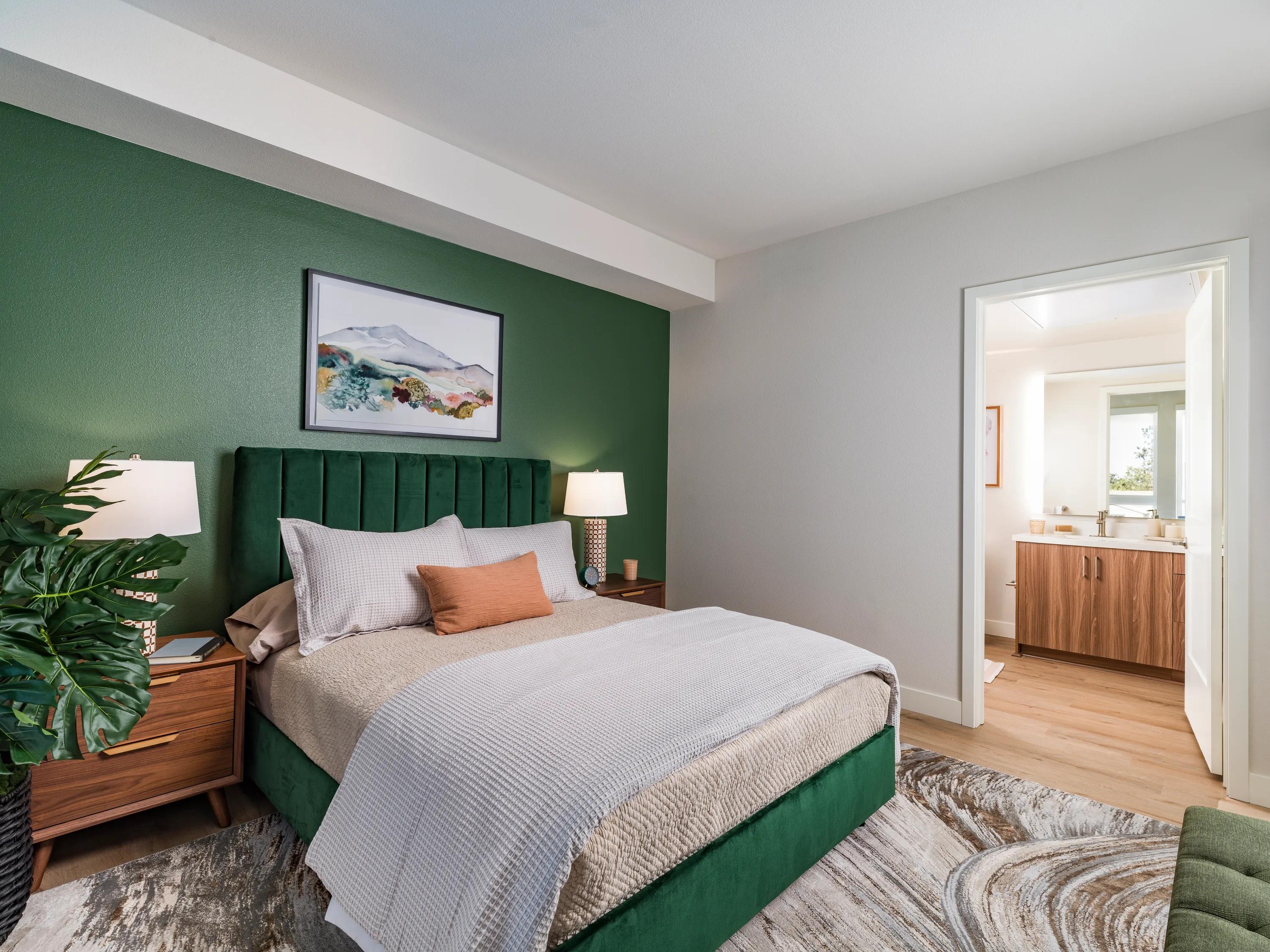 bedroom with green paint and furniture leading into bathroom modera pomona apartment homes for rent in ca