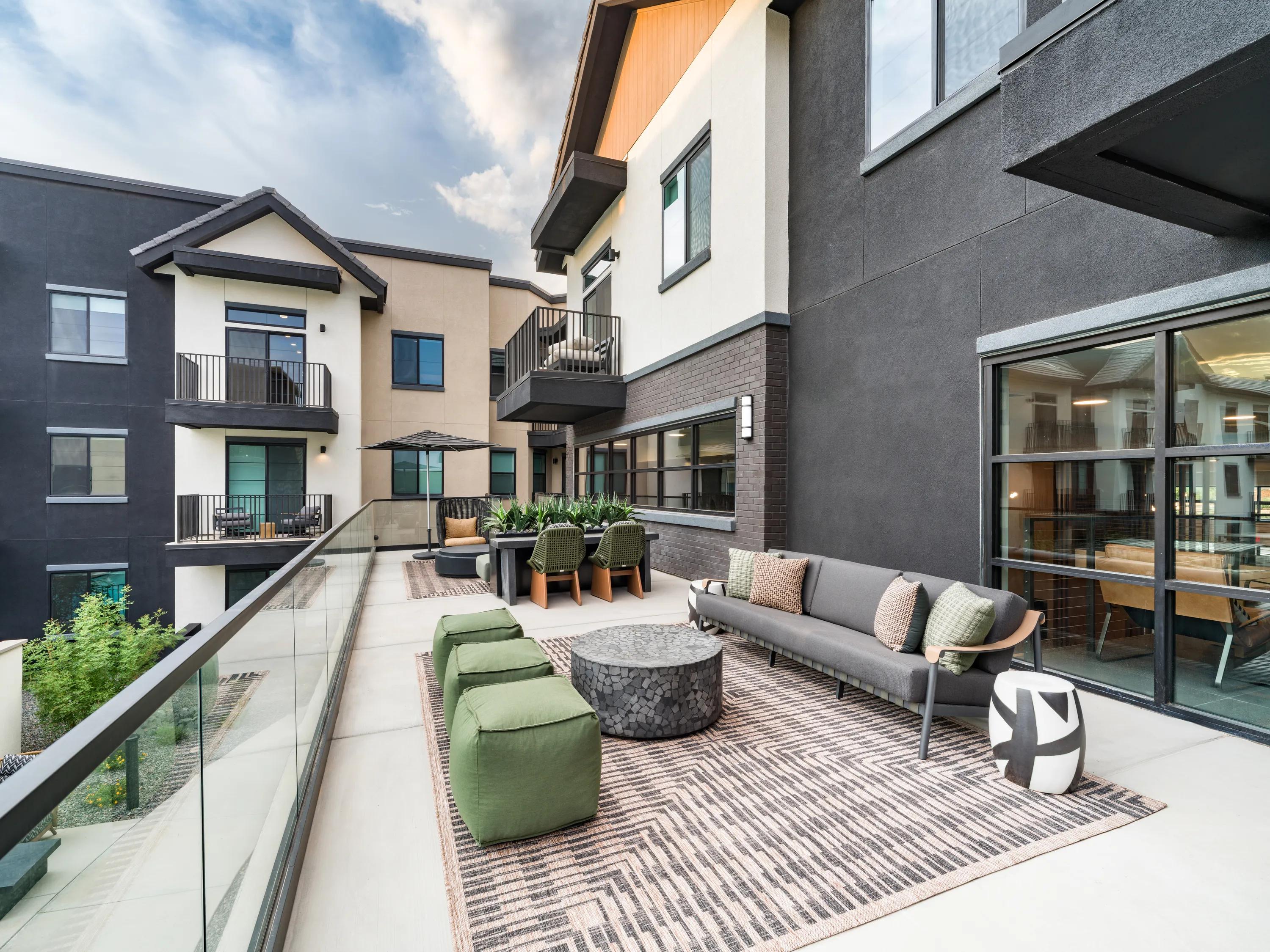 Outdoor sky lounge with modern seating, glass railings, conversational gathering areas, and views overlooking the community at apartments in Chandler, AZ.