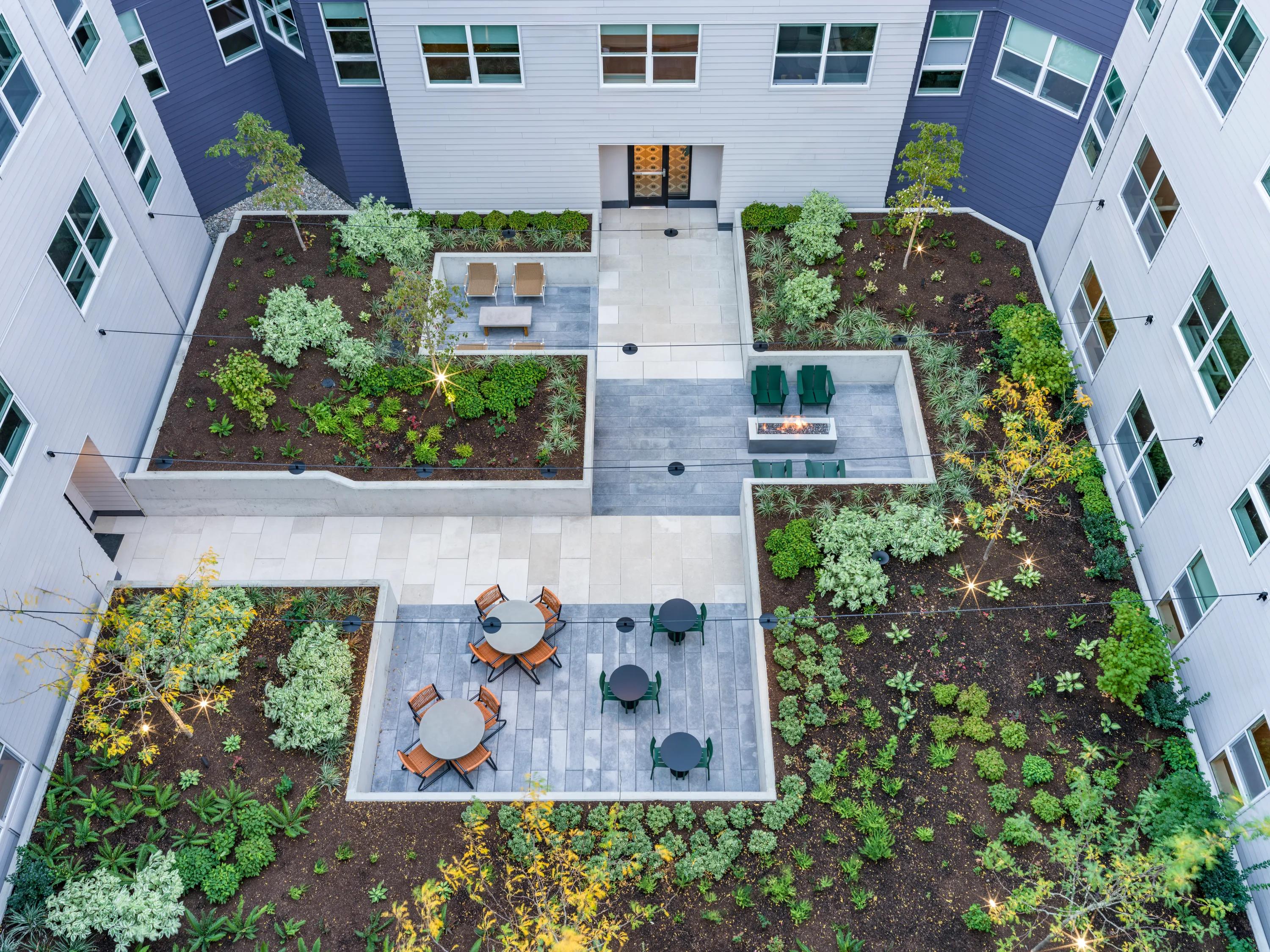 outdoor courtyard with seating and fireplace at modera woodstock apartment homes for rent in portland or
