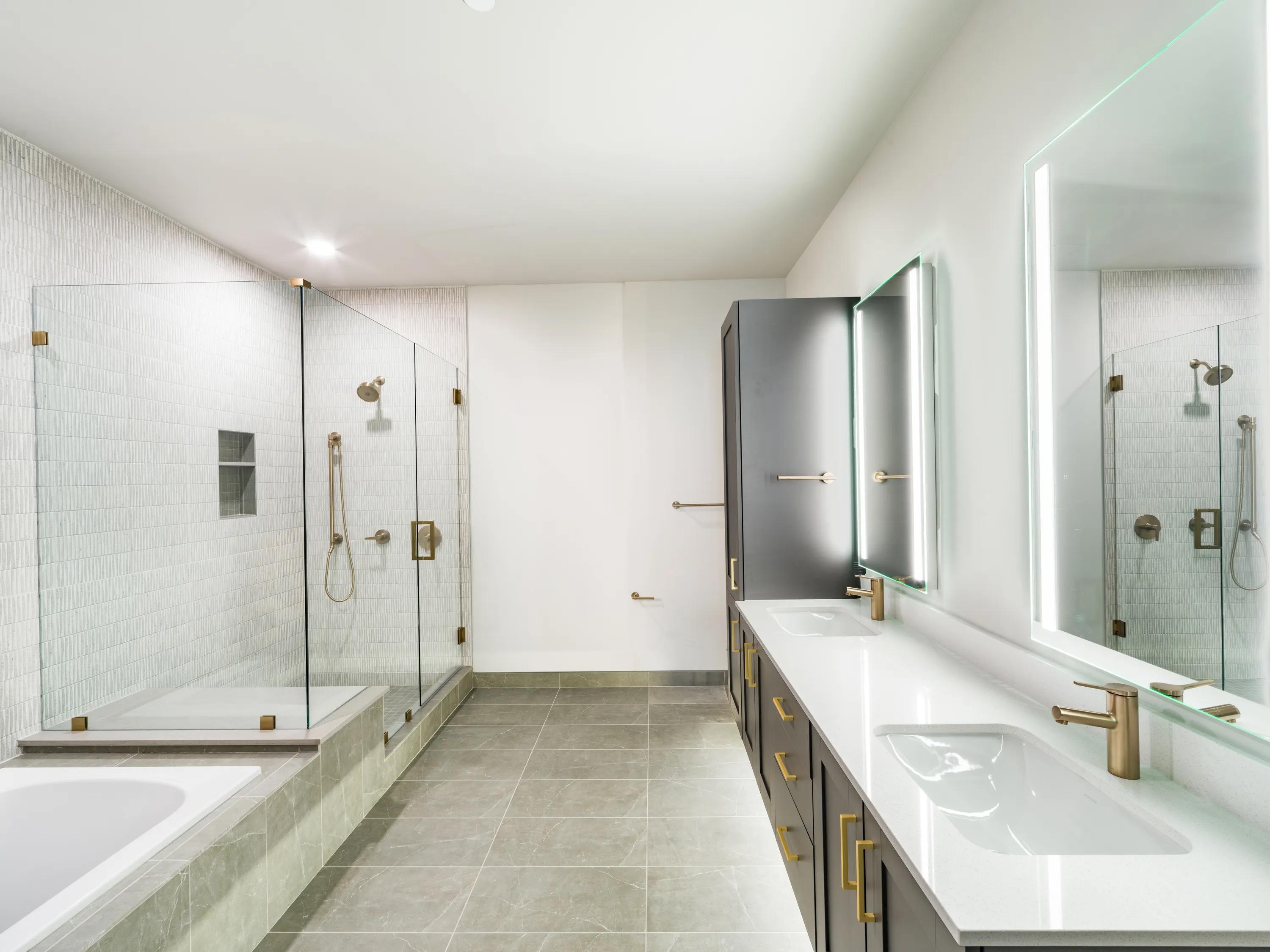 Designer bathrooms with double vanities, quartz countertops, and backlit mirrors