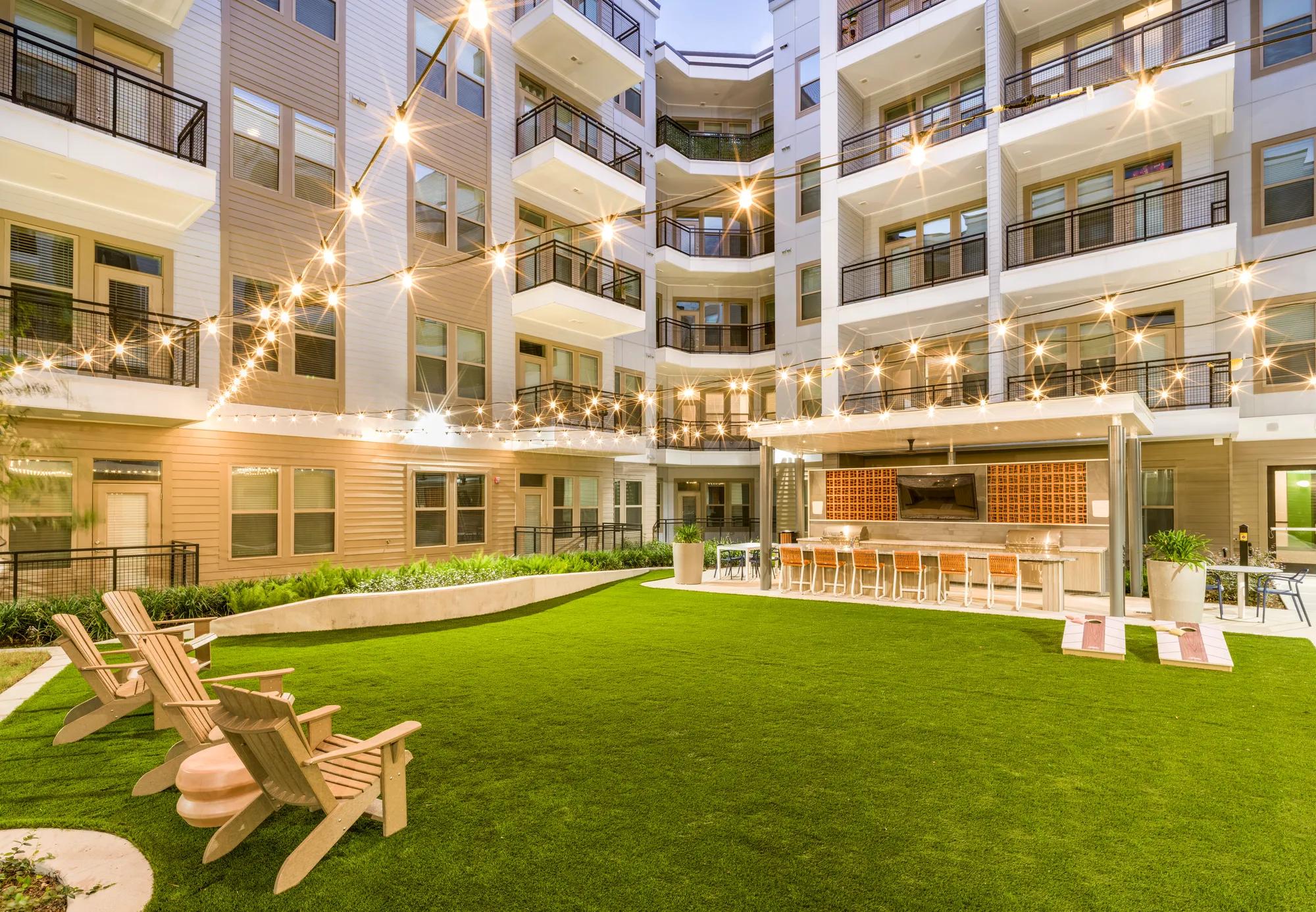 green spaces and activity lawn at dusk modera garden oaks apartments houston tx