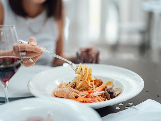 Woman eating italian food at restaurant