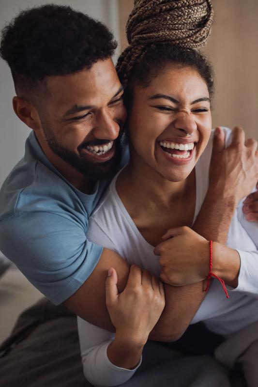 couple hugging while sitting in a comfortable bedroom modera scottsdale apartments
