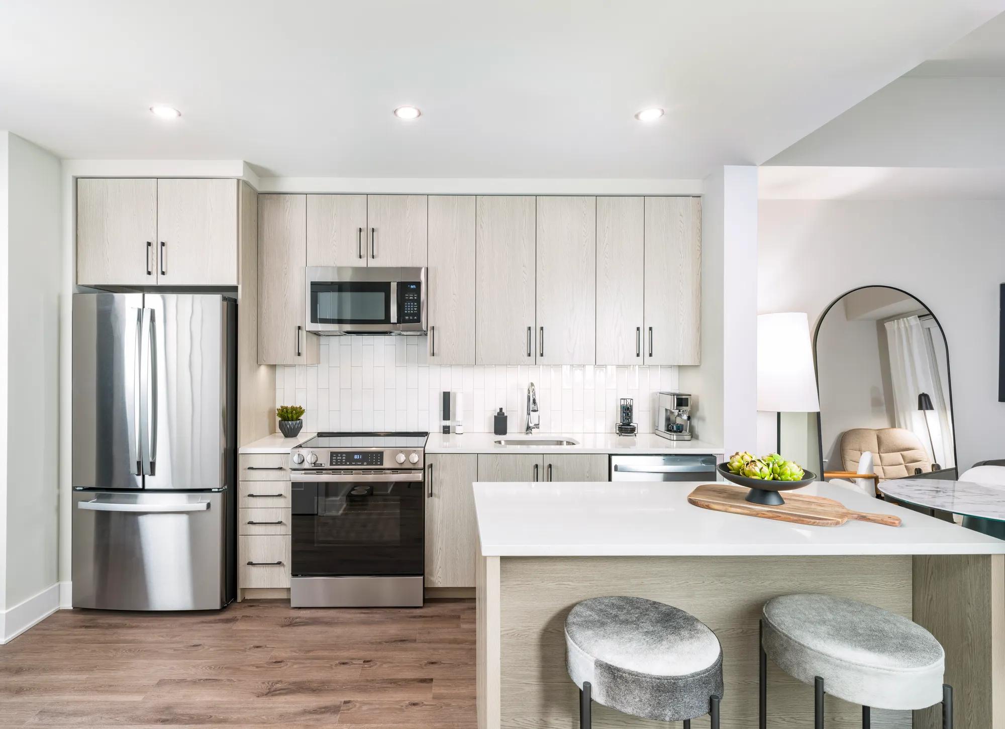 spacious kitchen with stainless appliances and light wood cabinetry modera h street apartments washington dc