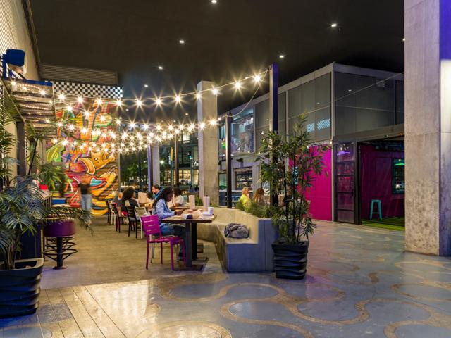 Cheerful, positive, happy young people, friends meeting outdoors, in cafe, having fun and drinking cocktails. Concept of party, leisure time, fun and joy, weekends, celebration, youth culture