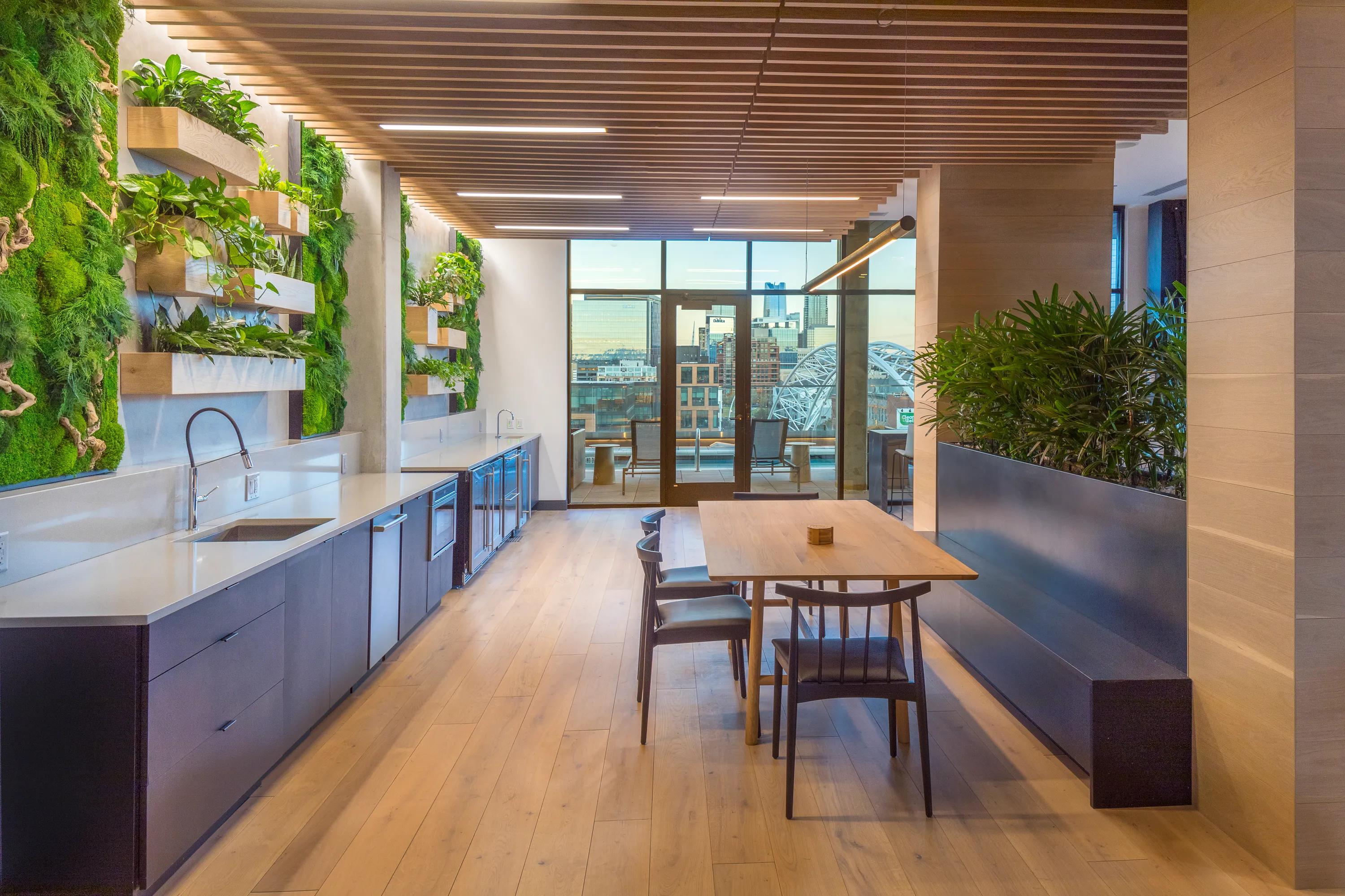 Clubroom with beautiful moss wall with dining areas and gorgeous views of Denver modera lohi apartments in denver co