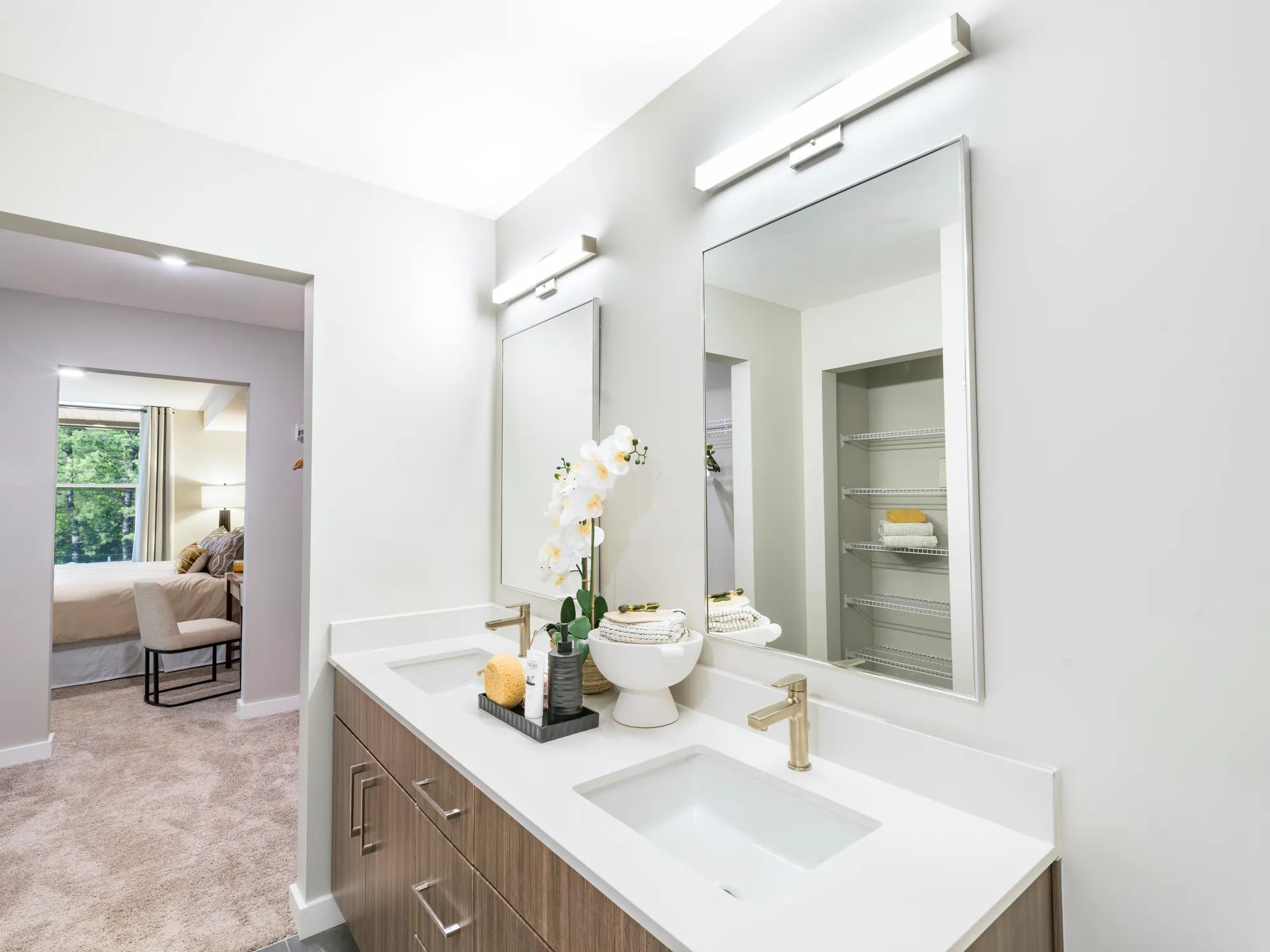 double vanity sink with white countertop and brown cabinetry modera loso apartment homes for rent in charlotte nc