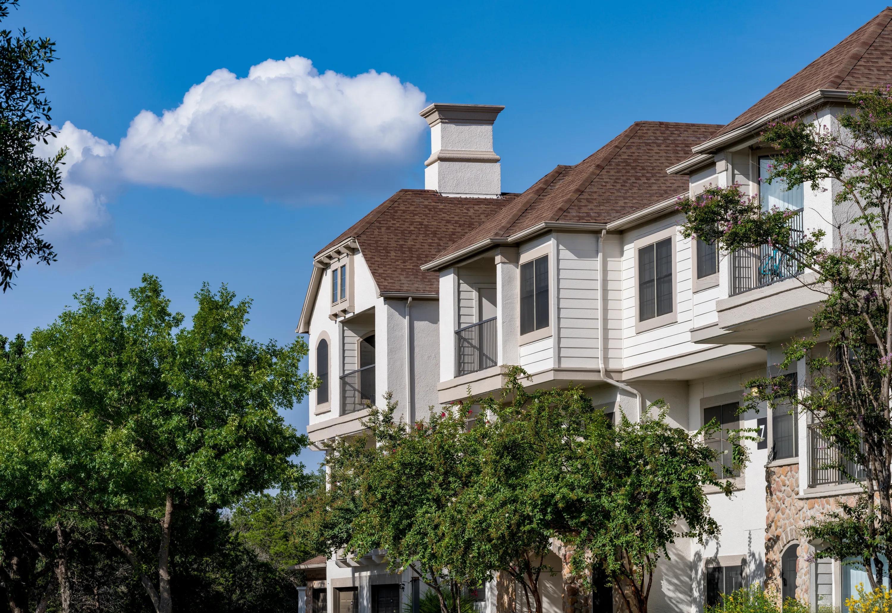 exterior building of building surrounded by lush landscaping alister sunset valley apartment homes for rent in austin tx
