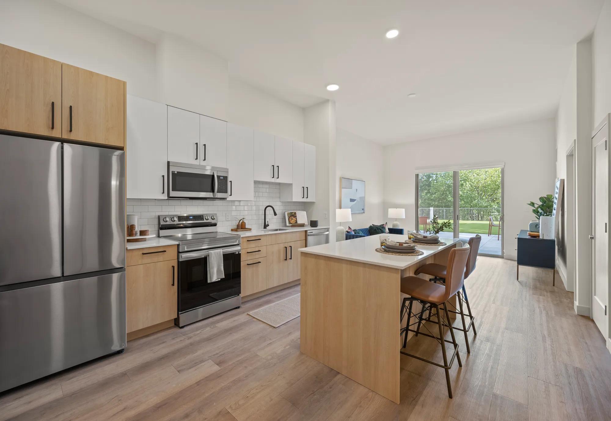 large kitchen with island and two toned cabinetry at modera newton apartment homes for rent in ma