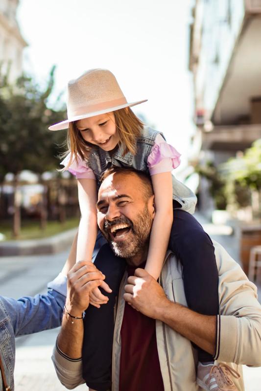 young family with daughter on dad shoulders while walking outside modera frisco square apartments in frisco tx