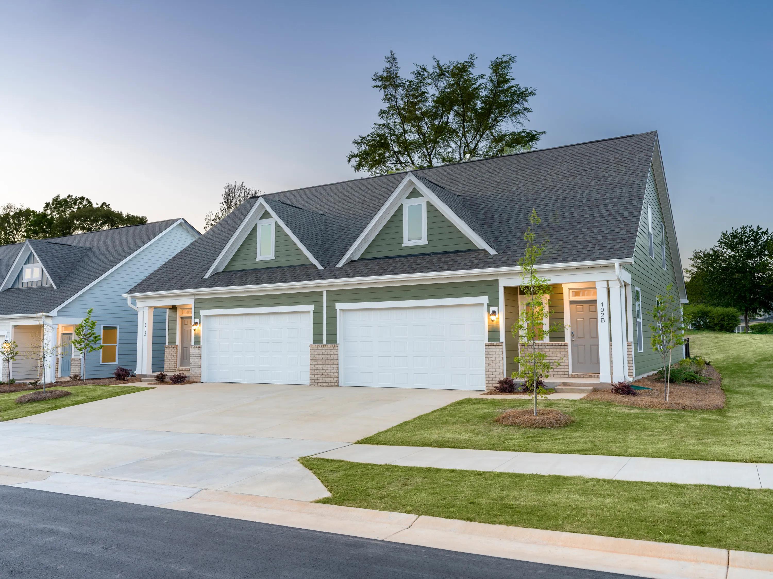large tree behind home with tasteful landscaping at dusk amavi mooresville apartment homes for rent in nc