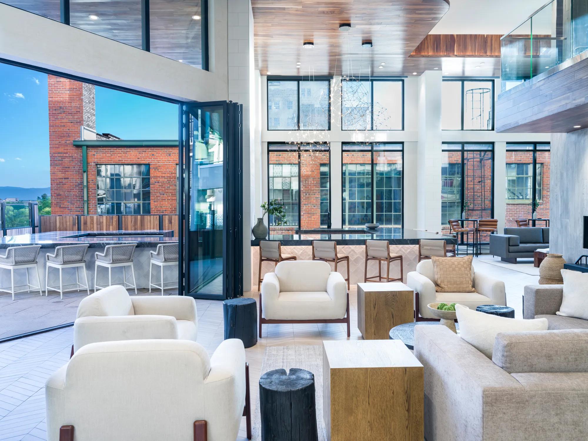 indoor outdoor space with seating and large windows leading to patio clubhouse modera golden triangle apartment homes for rent in denver co