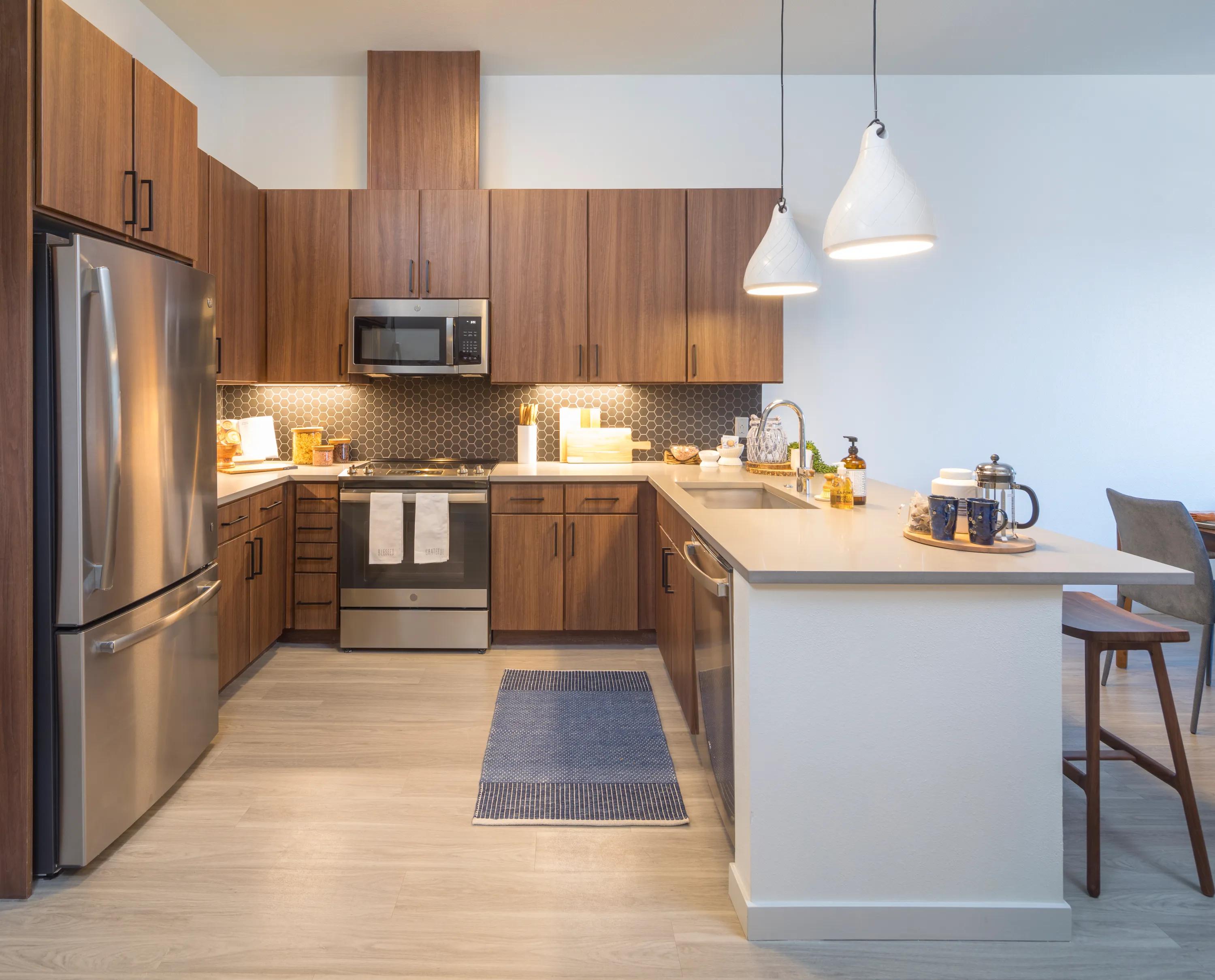 Modern kitchen with stainless steel appliances at Modera West Wash Park apartments in Denver.