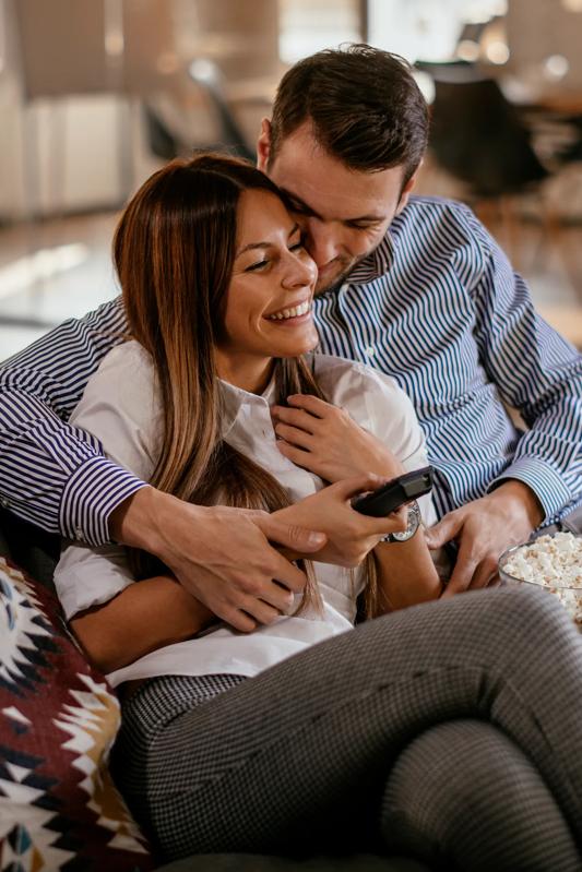 couple cuddling on couch watching tv with popcorn modera mckinney ridge in mckinney tx