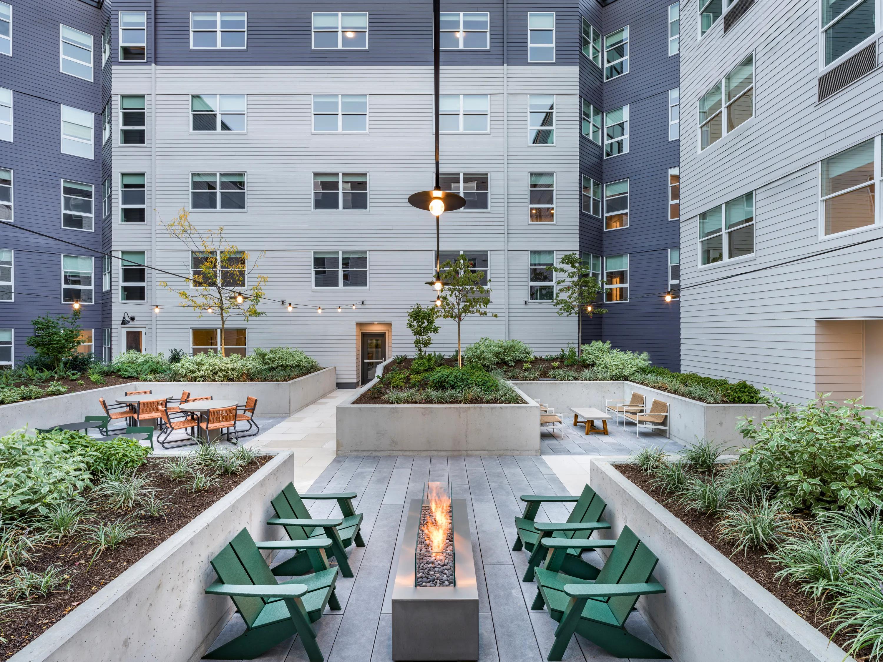 Modera Woodstock's landscaped courtyards with lounge seating and fire table