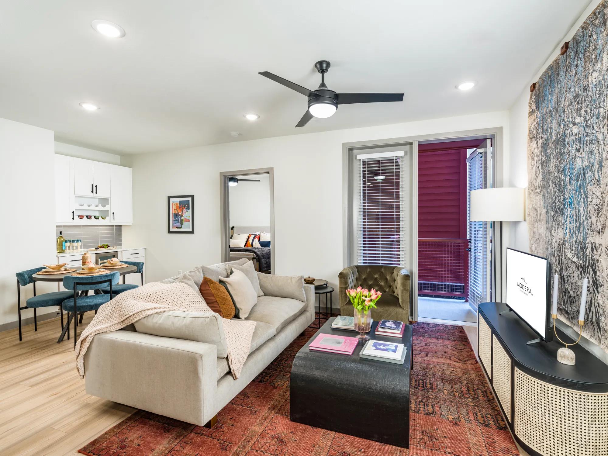 spacious living areas with ceiling fans and hardwood style flooring