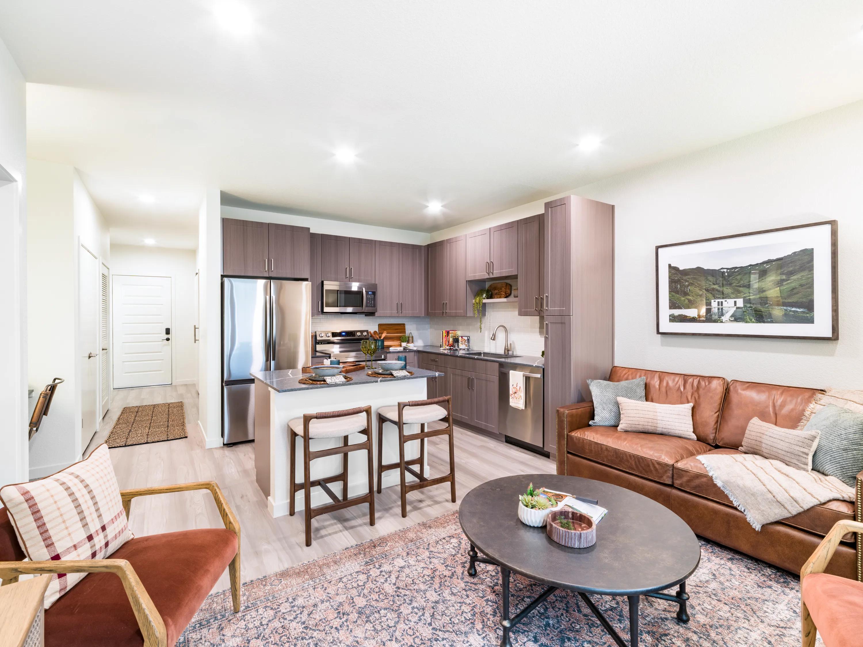 kitchen with wood grain cabinetry and stainless steel appliances at modera university park apartment homes for rent in denver co