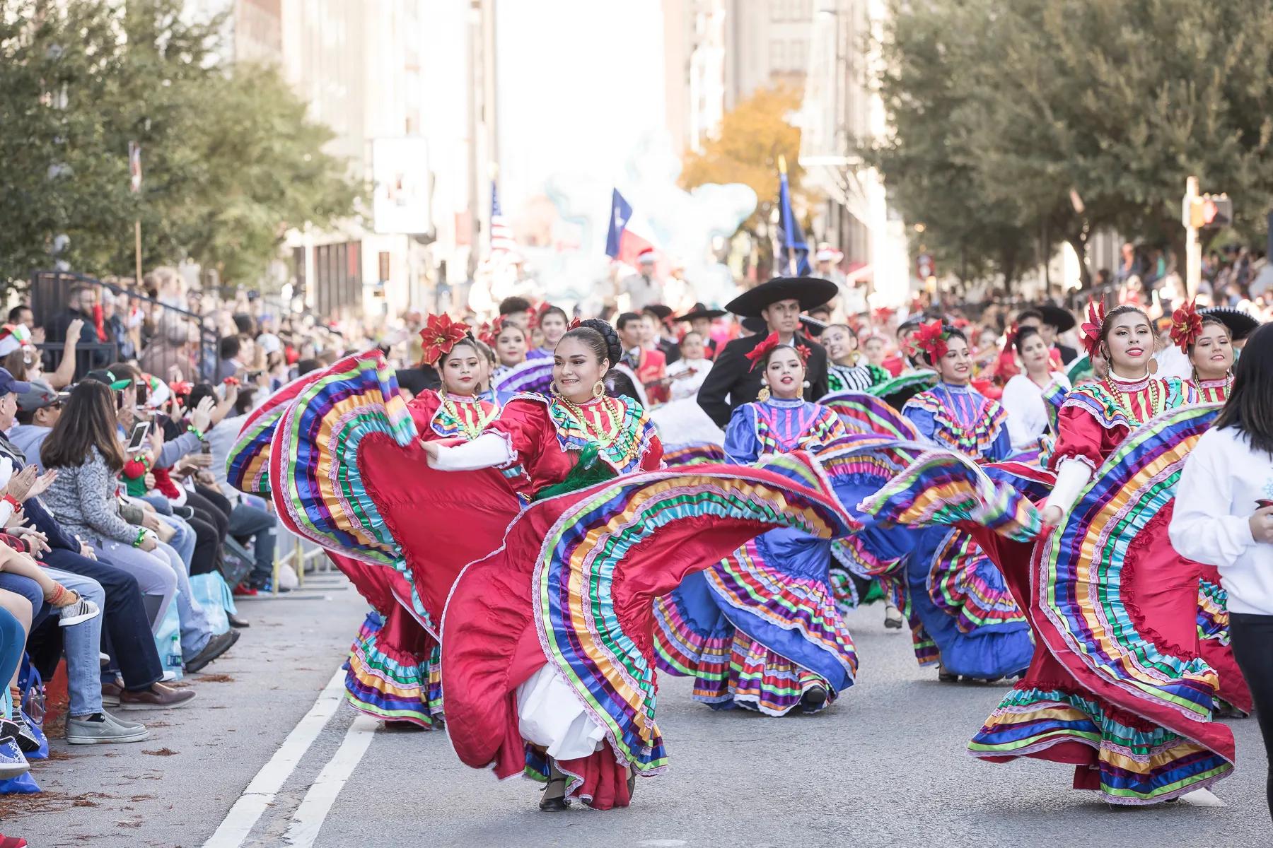 woman dancing in a street parade wearing traditional clothing modera st paul dallas tx
