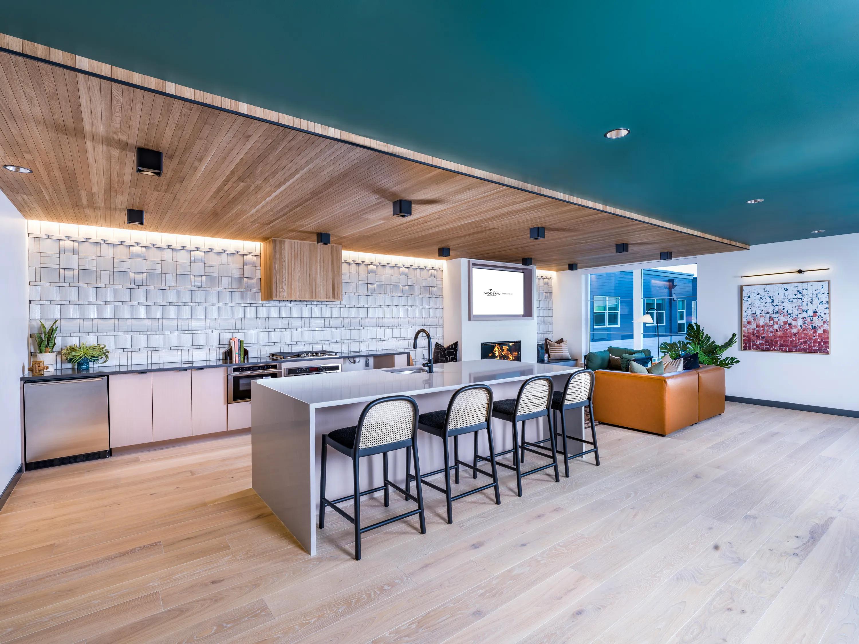 demonstration kitchen and fireplace in clubroom at modera woodstock apartment homes for rent