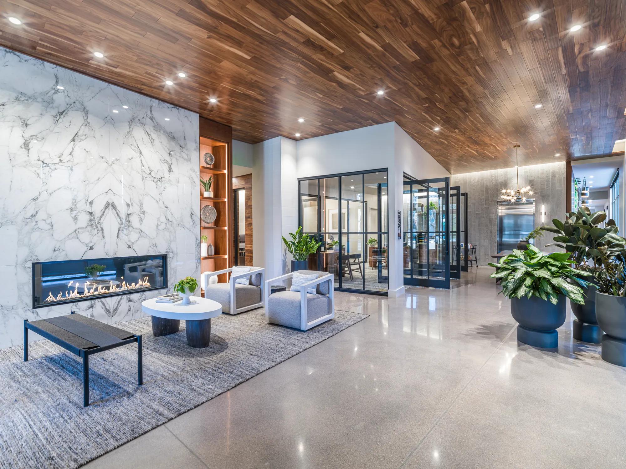 comfortable community area with fireplace and lounge seating modera golden triangle apartments