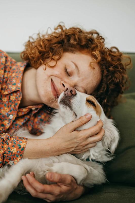 woman with red curly hair hugging white an tan dog upper ivy apartments in culver city