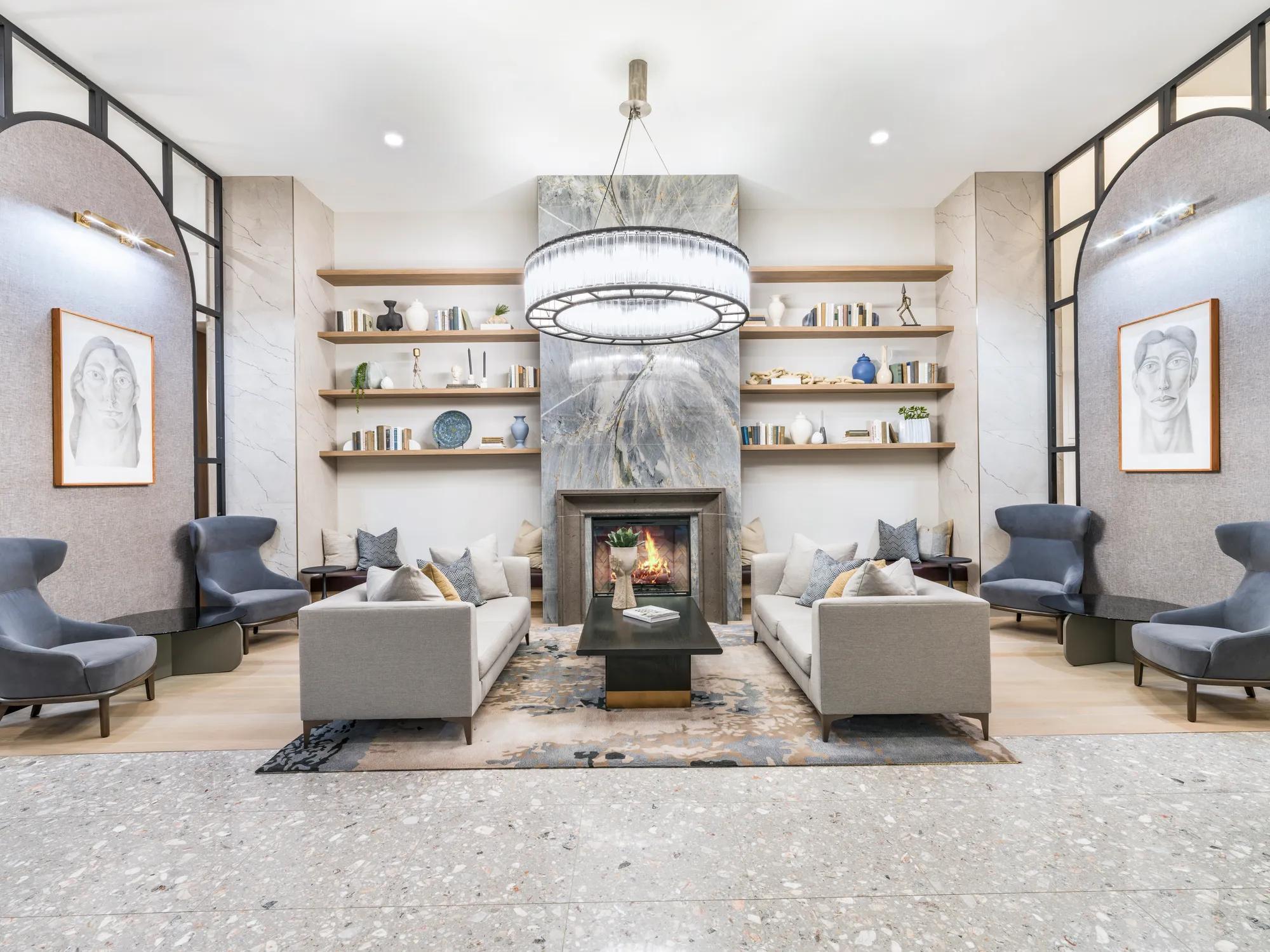 modern clubroom with white walls, light colors tile flooring, moderan dark accents, and comfortable lounging couches and working areas at modera waugh apartments