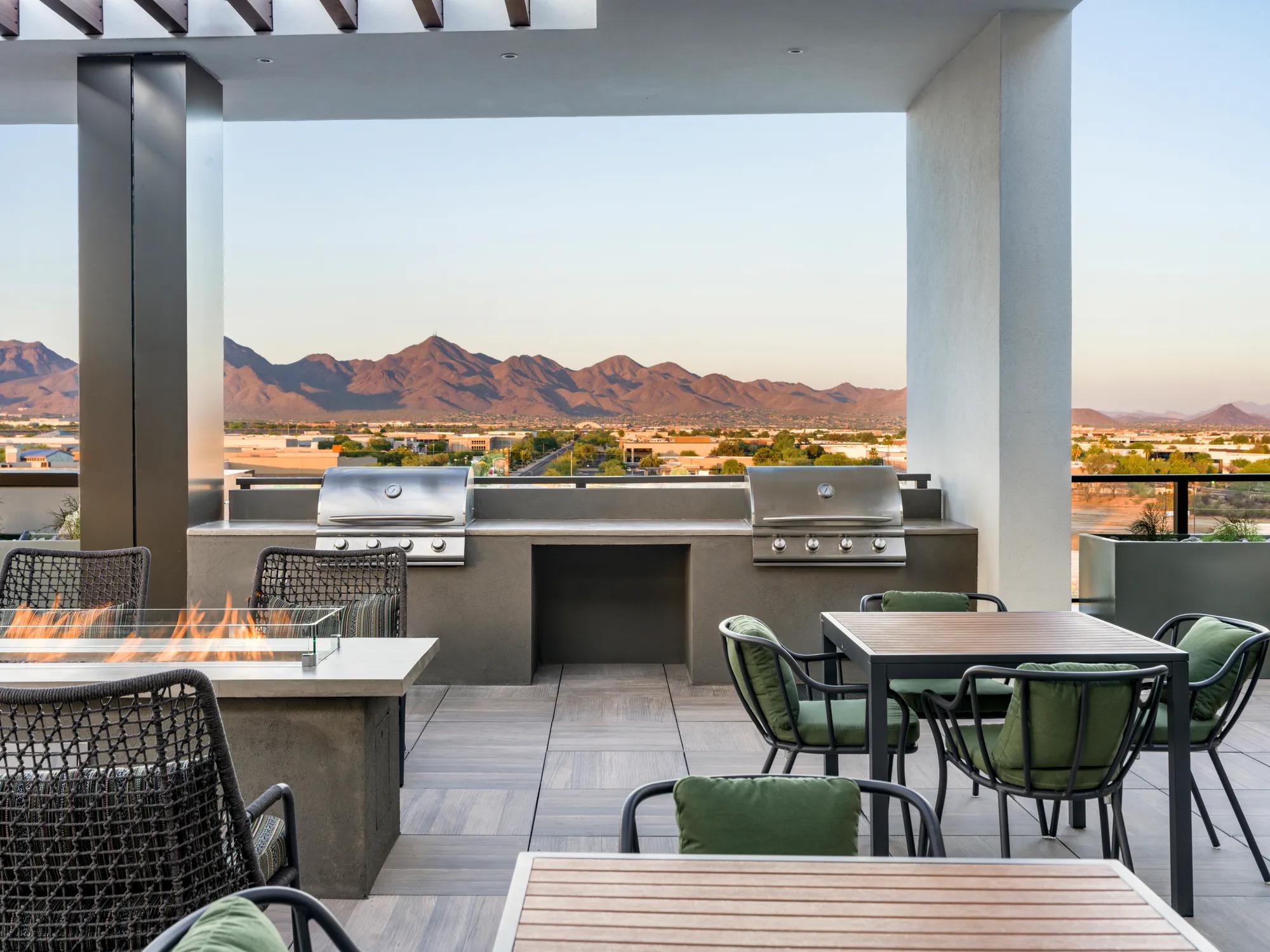bbq grills on rooftop with mountain views in distance at modera scottsdale apartment homes for rent in scottsdale az