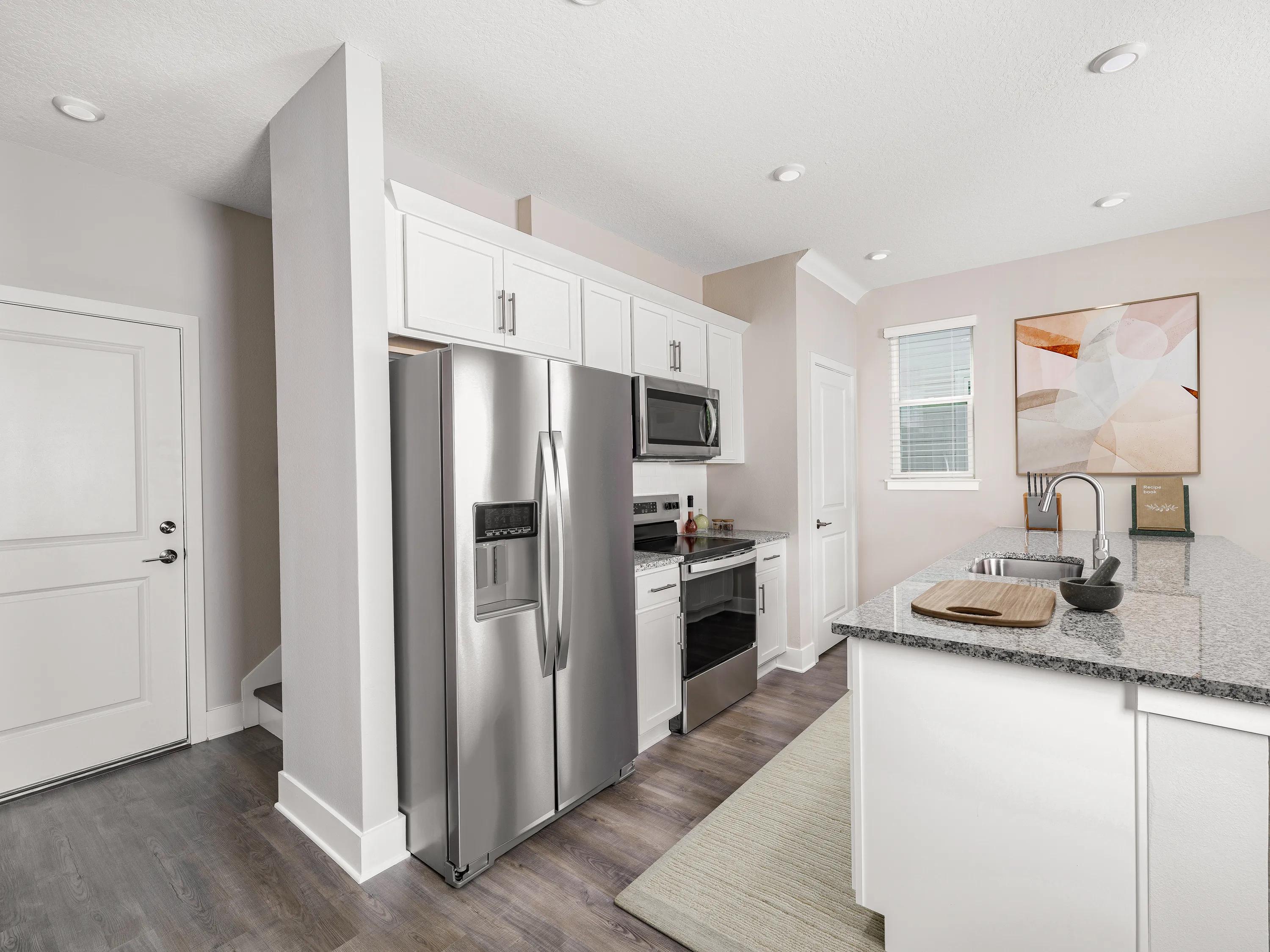 kitchen with stainless steel appliances and hardwood style flooring amavi kissimmee homes for rent in kissimmee fl
