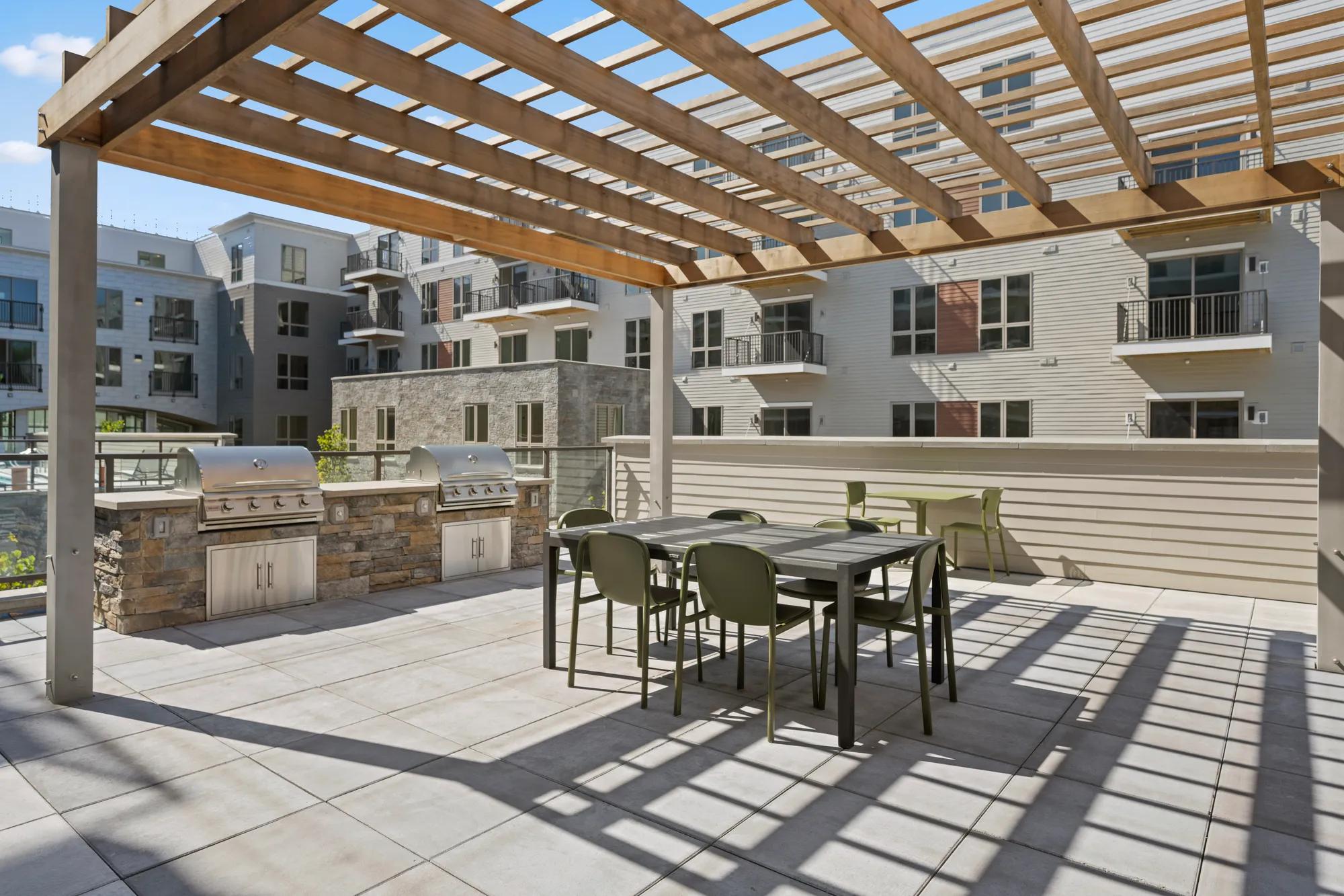 grilling and bbq cooking and dining area in courtyard at modera newton apartment homes for rent in ma