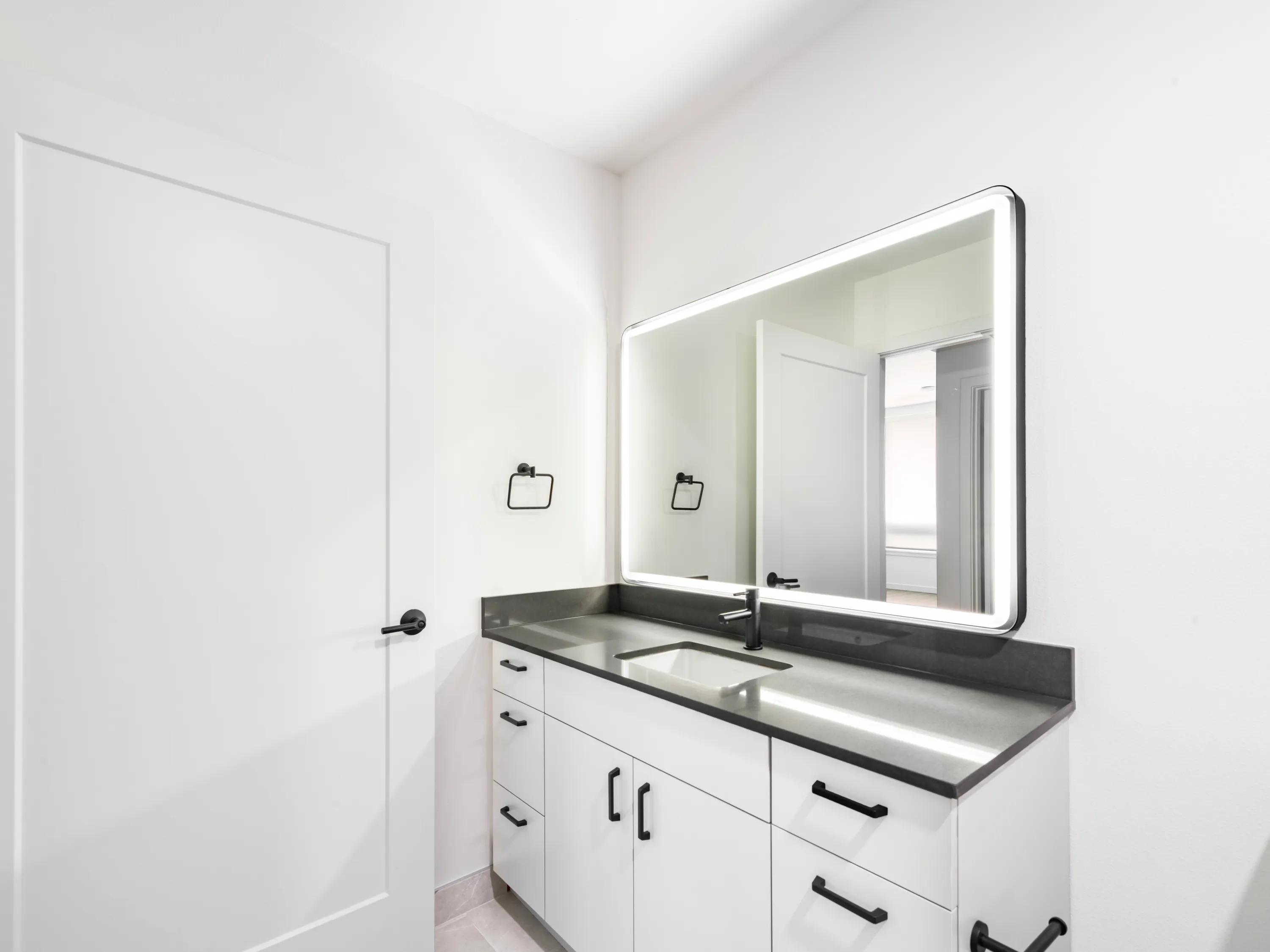 bathroom with backlit mirror and white cabinetry modera bridle trails apartment homes for rent