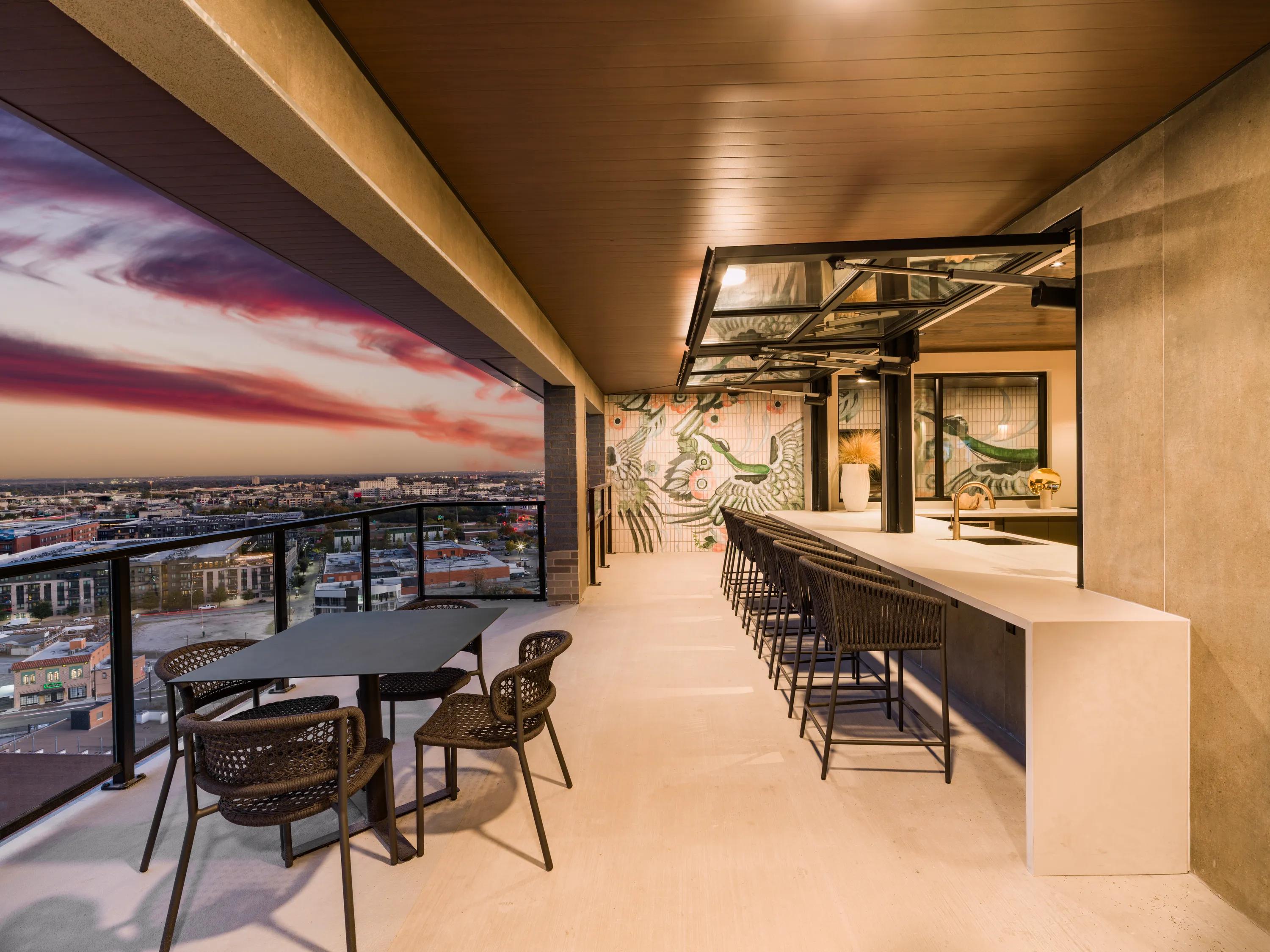 indoor outdoor sky lounge at dusk with bar seating modera st paul apartment homes for rent