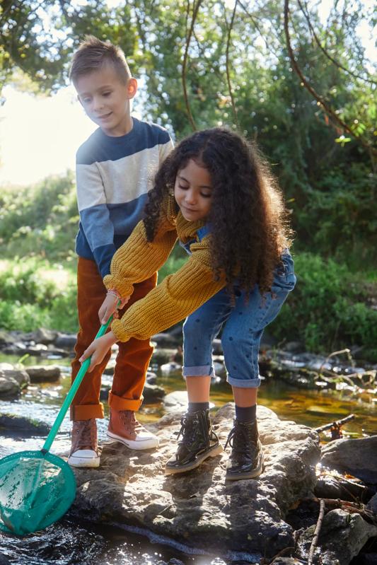 two kids playing with fishing net in a creek modera mckinney ridge in mckinney tx