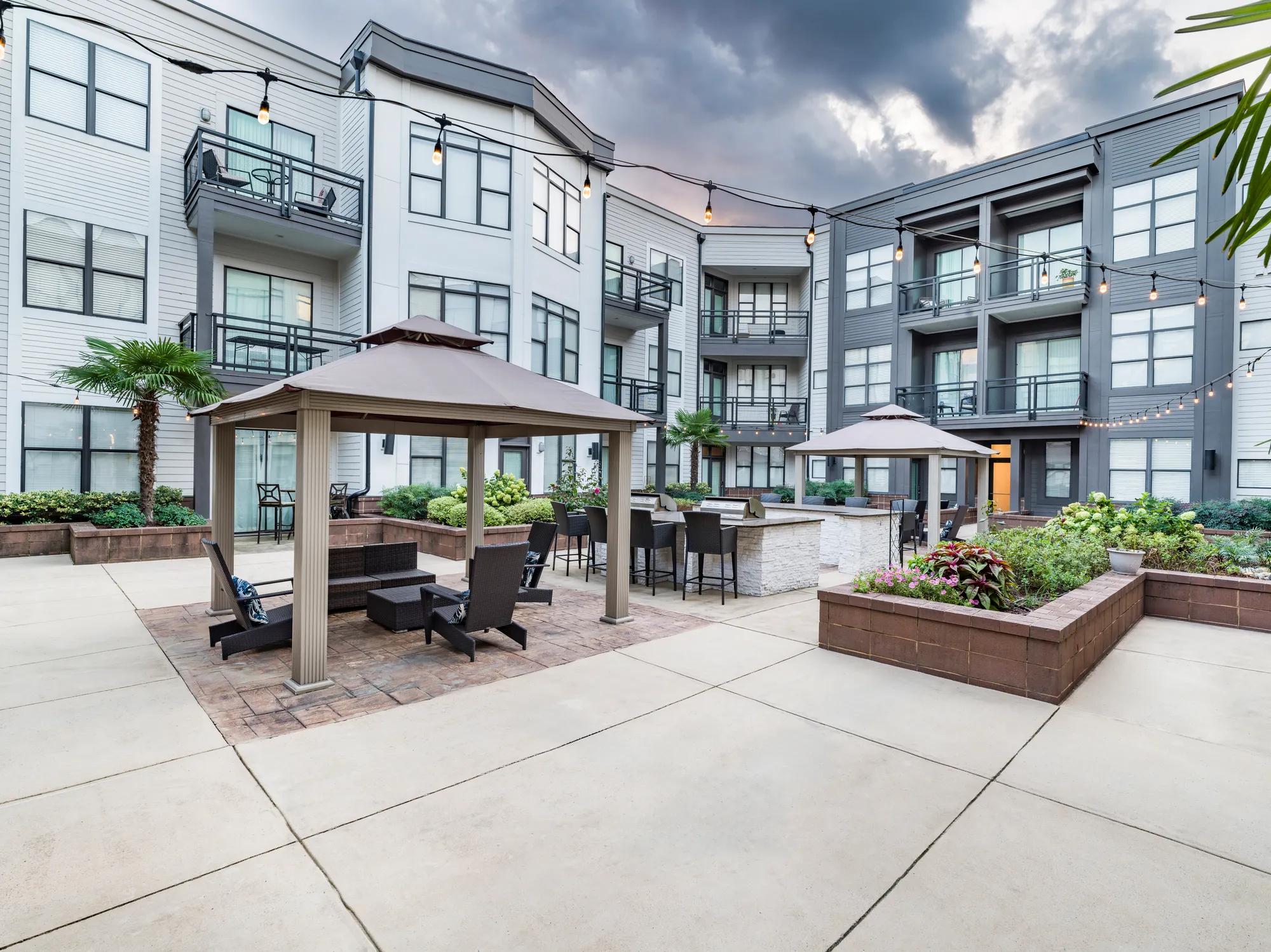 covered outdoor seating and bbq area with dining alister uptown apartment homes for rent in charlotte nc