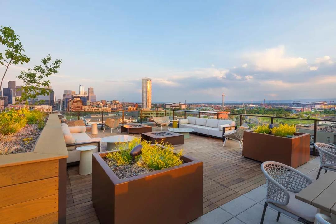 Rooftop deck with lush landscaping, fire pits, outdoor tv, plus city and mountain views modera lohi apartments in denver co