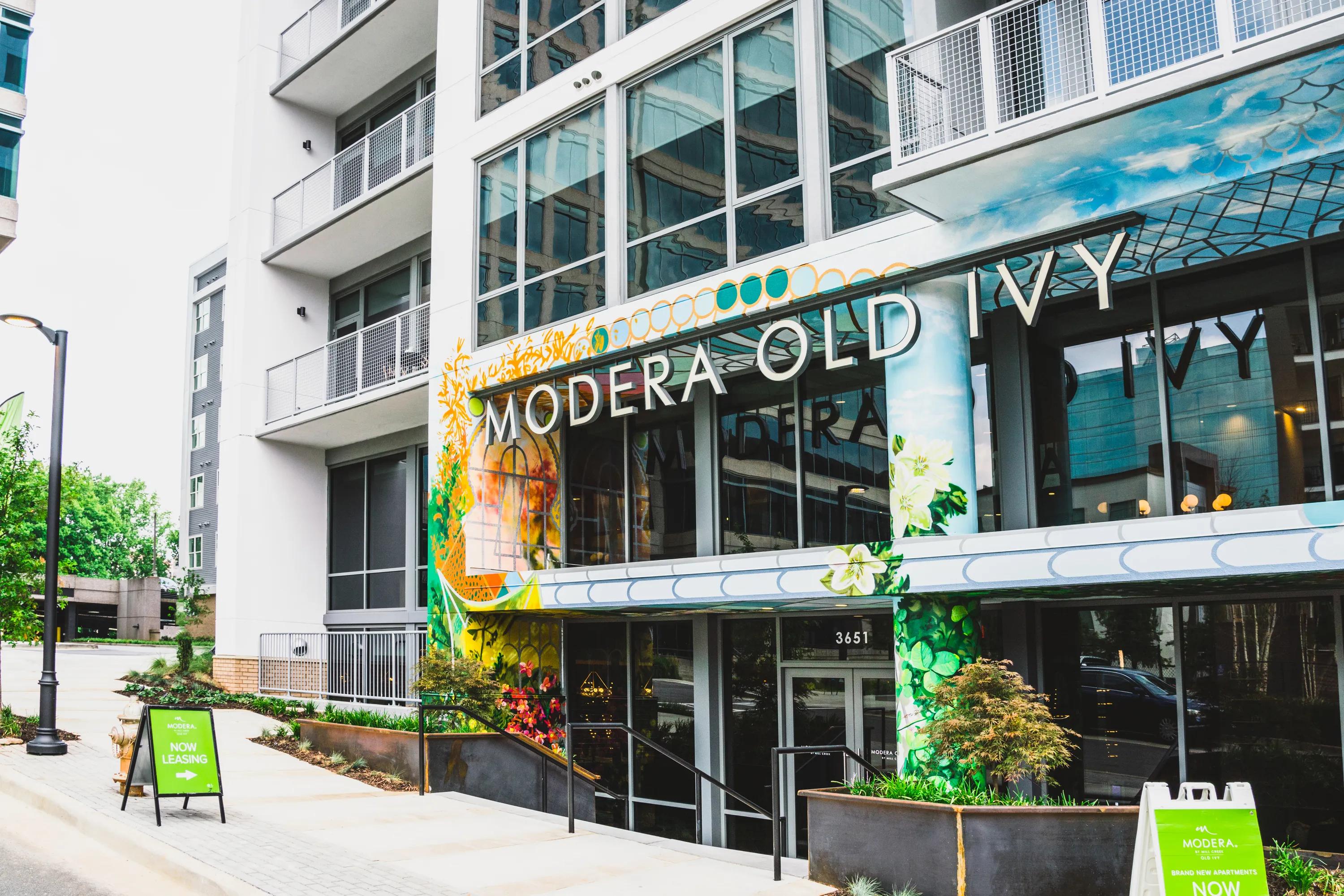 Image of building exterior modera old ivy apartments with painted art at entrance