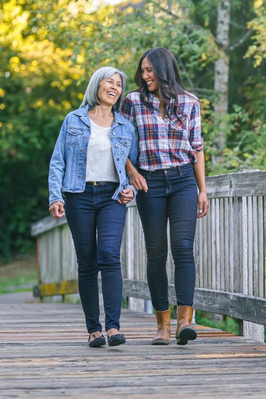 mature mother and daughter walking along a bridge near modera beaverton portland