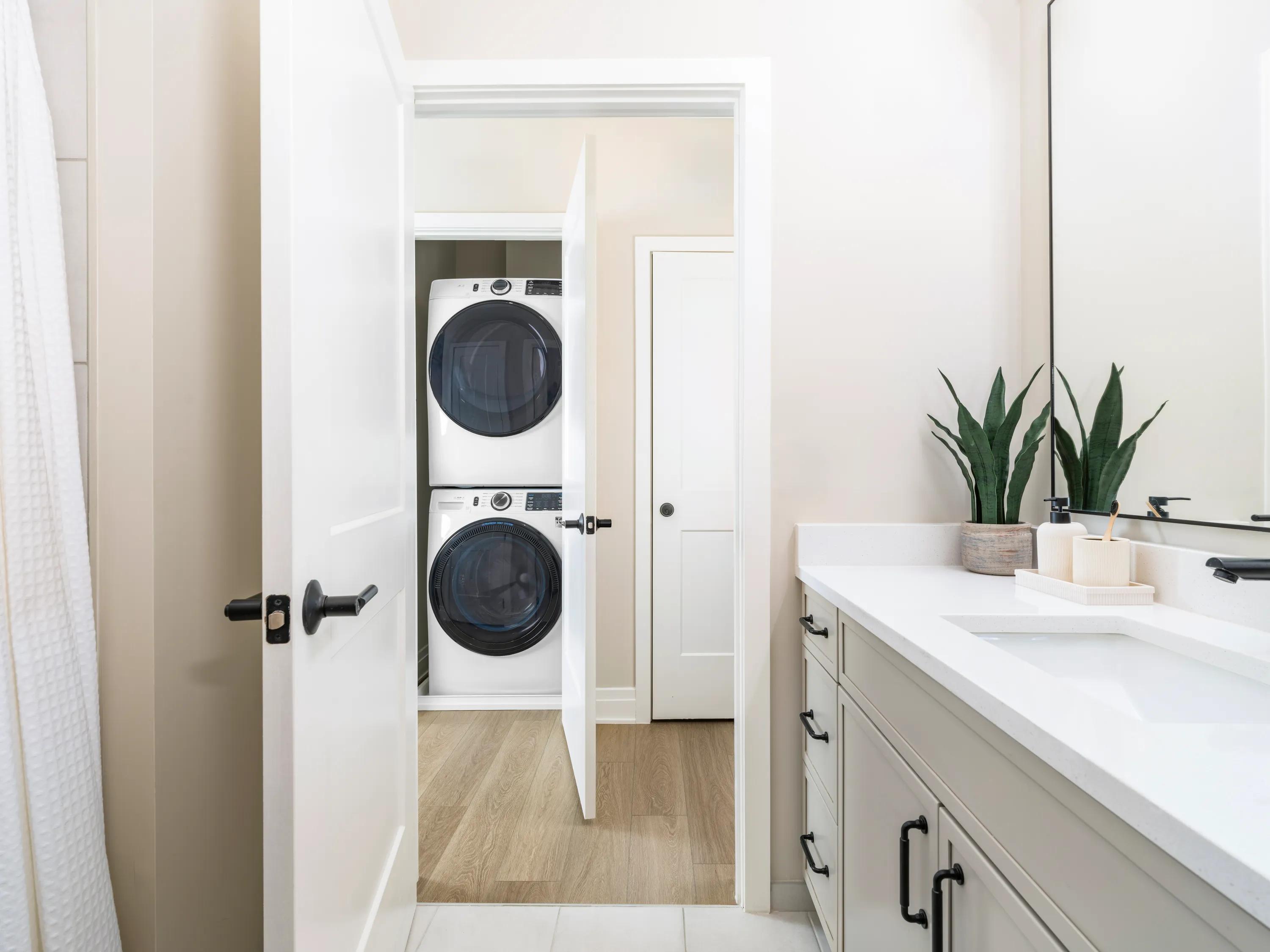 bathroom leading onto hallway with washer and dryer closet modera falls church apartment homes for rent in va