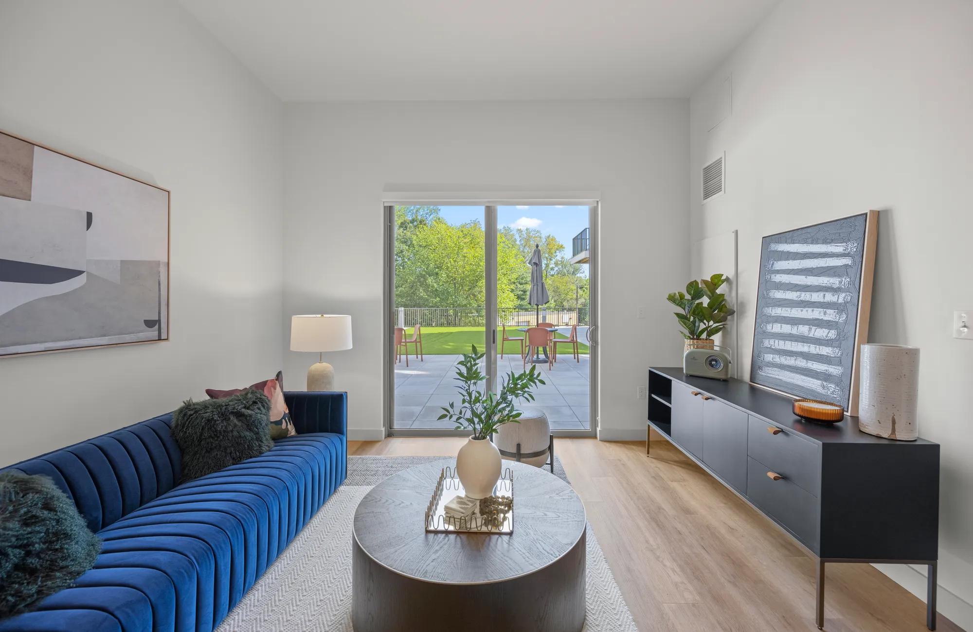 living room with large glass doors looking onto courtyardat modera newton apartment homes for rent in ma