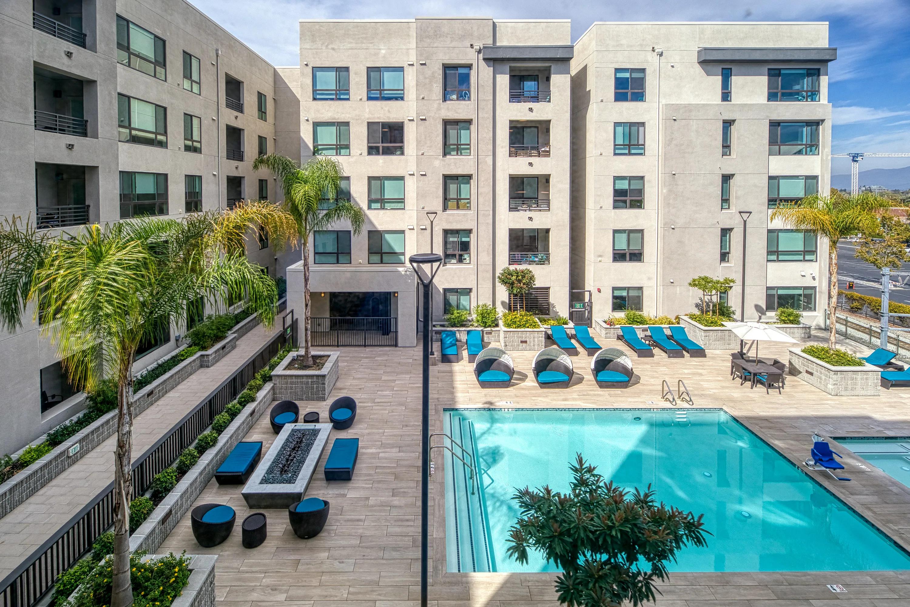 Elevated resort-inspired pool deck and spa with daybed seating and firetable vespaio apartments
