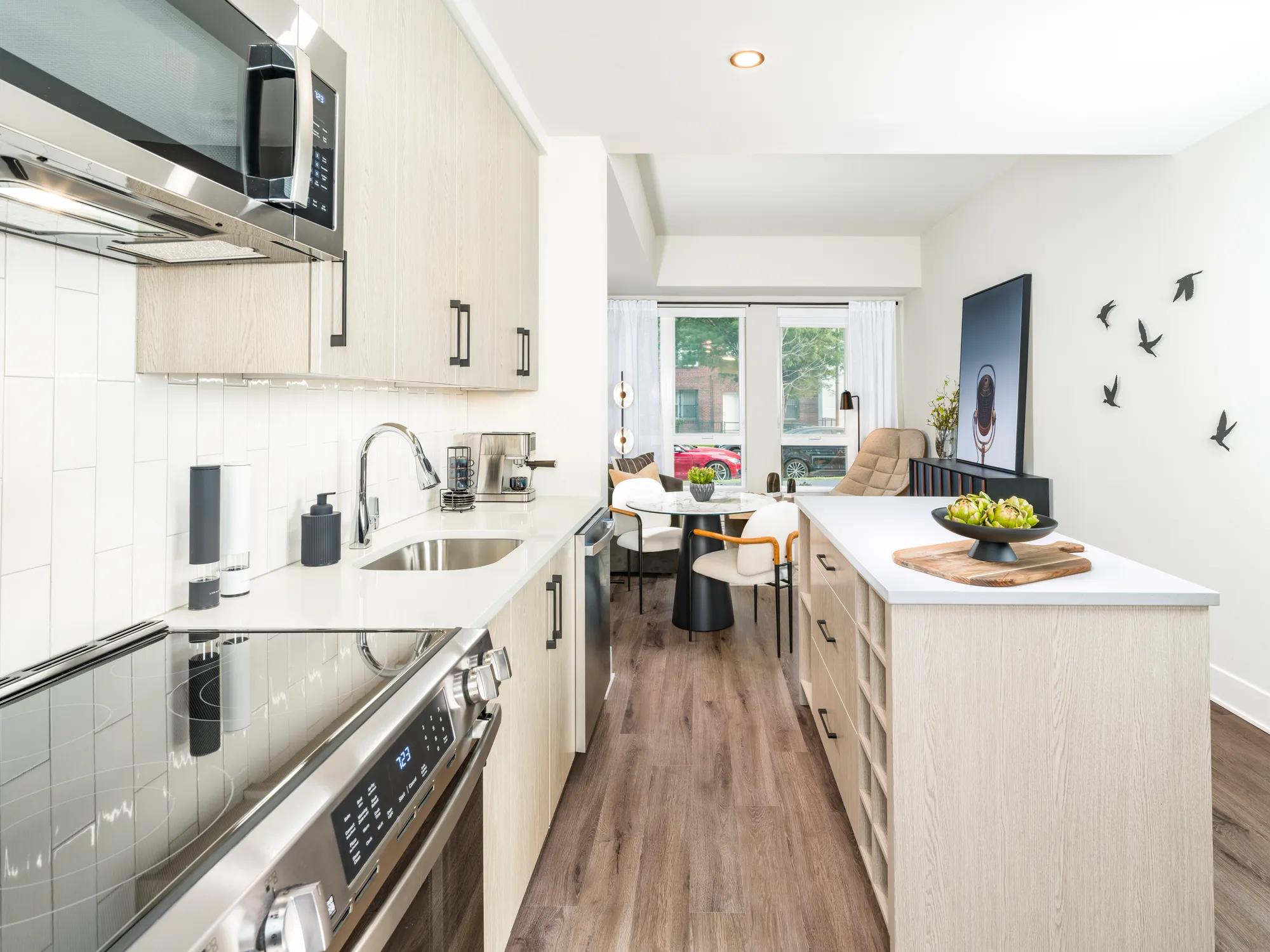 spacious kitchen with stainless appliances and light wood cabinetry modera h street apartments washington dc