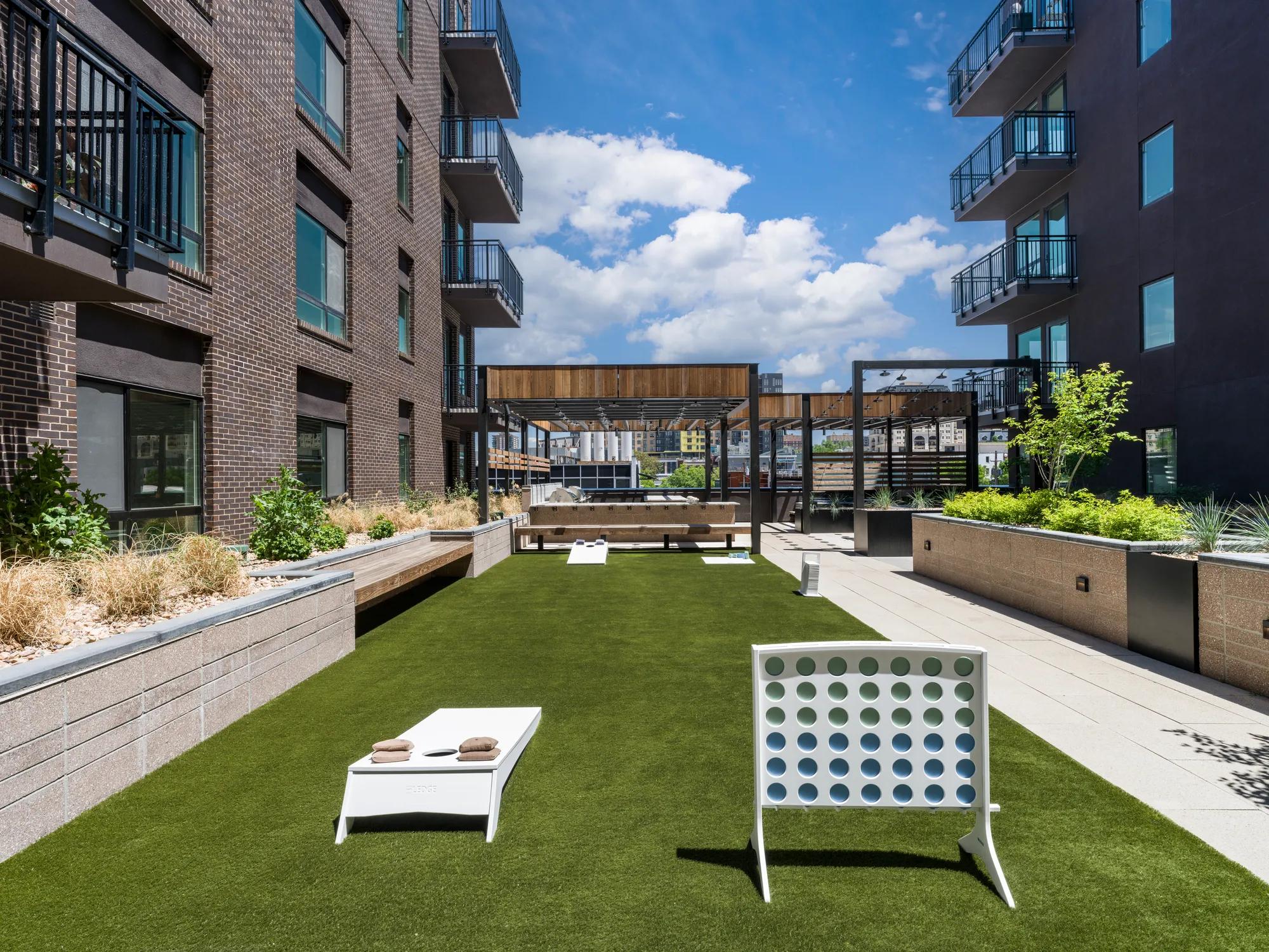 outdoor games on turf in courtyard on sunny day modera golden triangle apartment homes for rent in denver co