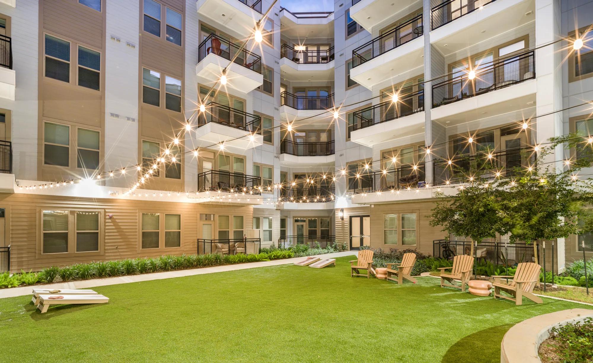 green spaces and activity lawn at dusk modera garden oaks apartments houston tx