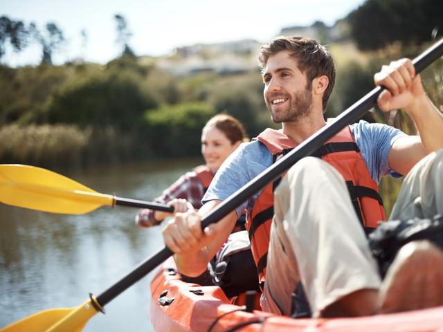 young couple kayaking in open lake modera needham apartments for rent in needham ma