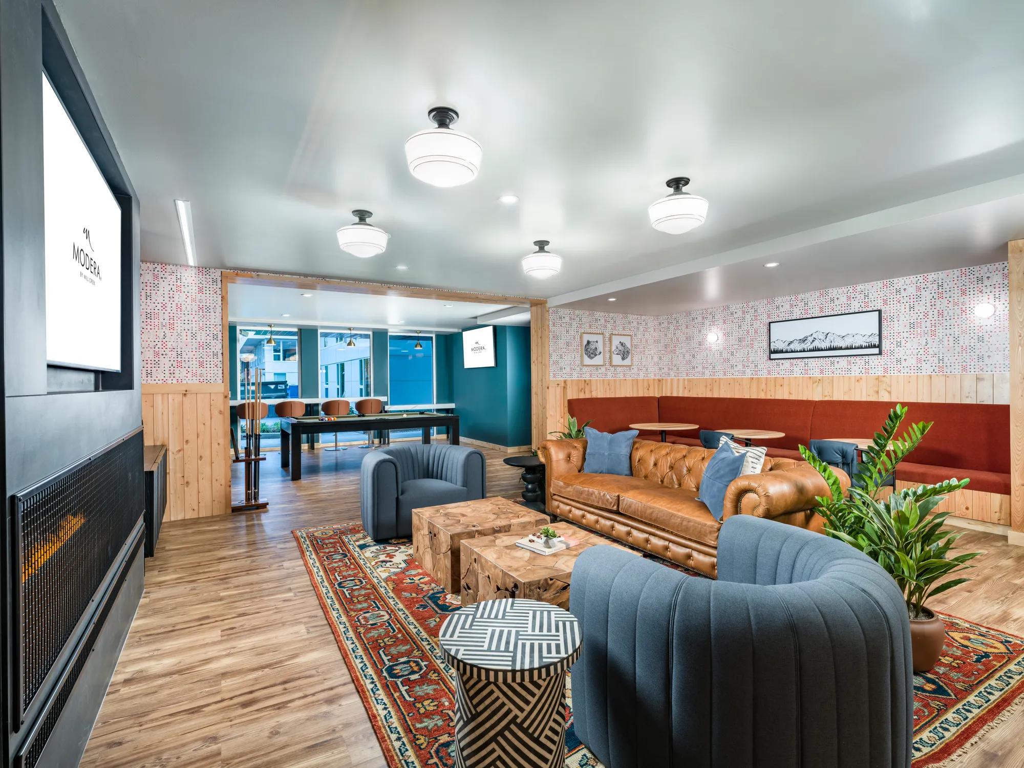 comunity clubroom with tvs and comfortable seating modera northgate apartments seattle wa