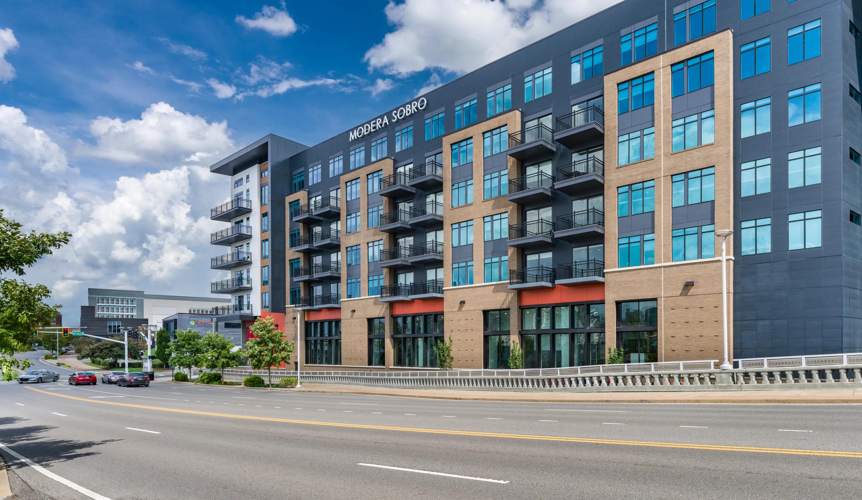 exterior building at street level on blue sky day at modera sobro apartment homes for rent in nashville tn