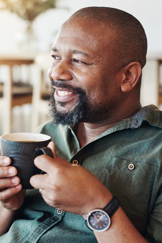 mature man drinking coffee and smiling modera frisco square apartments in frisco tx