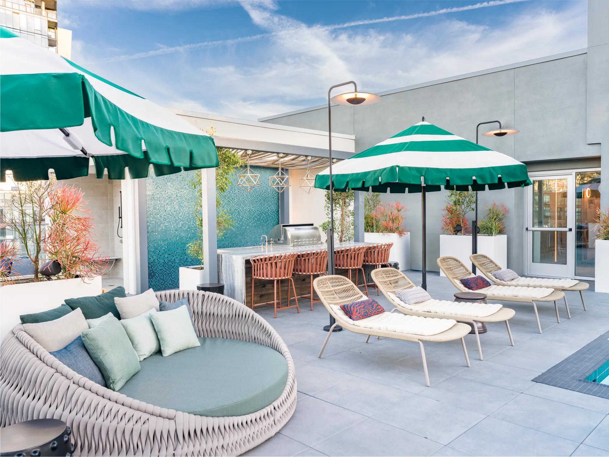 rooftop poolside lounge with large umbrellas for relaxation modera argyle apartments for rent in los angeles ca